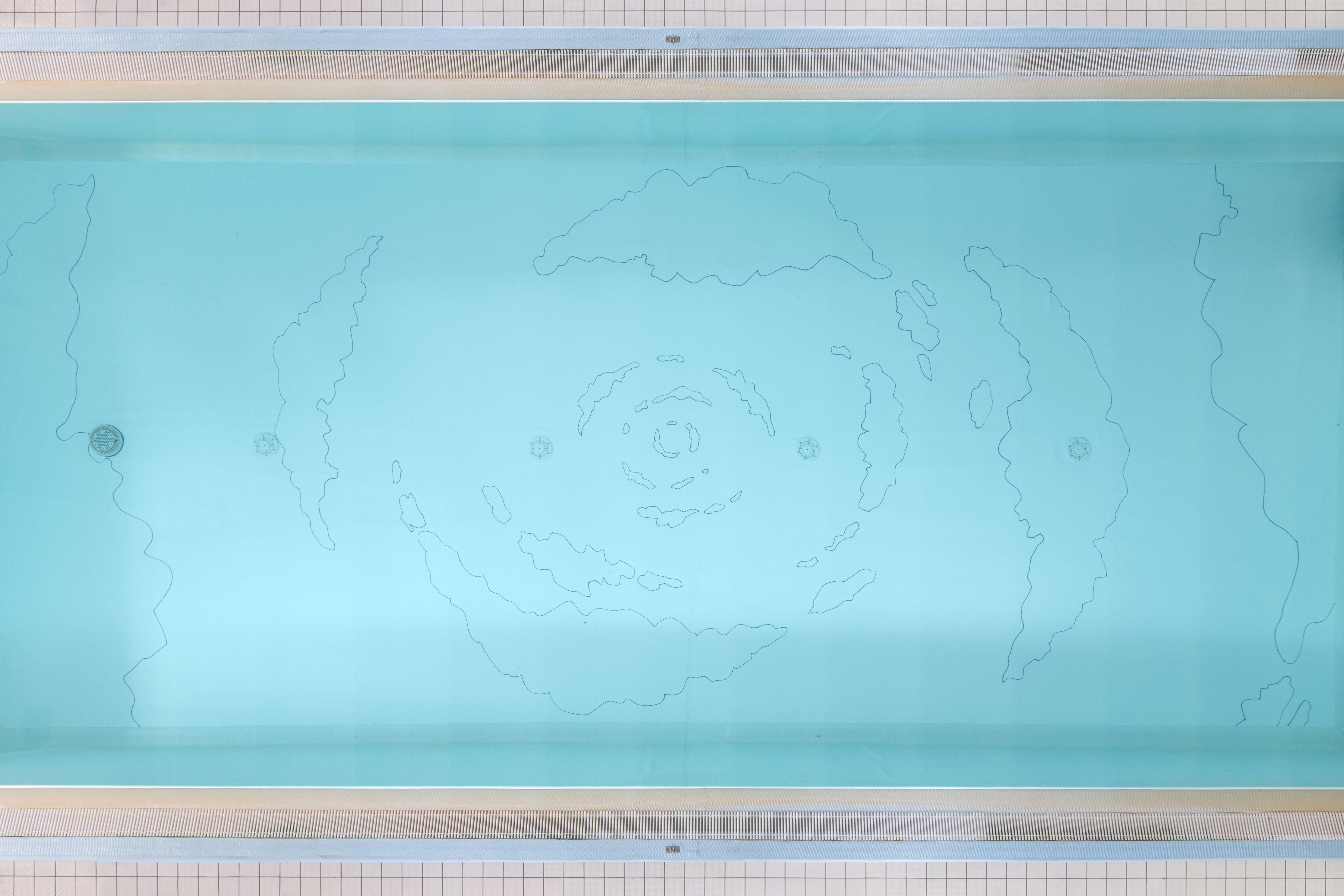 Top view of the pool with the spiral cloud drawing on its turquoise floor