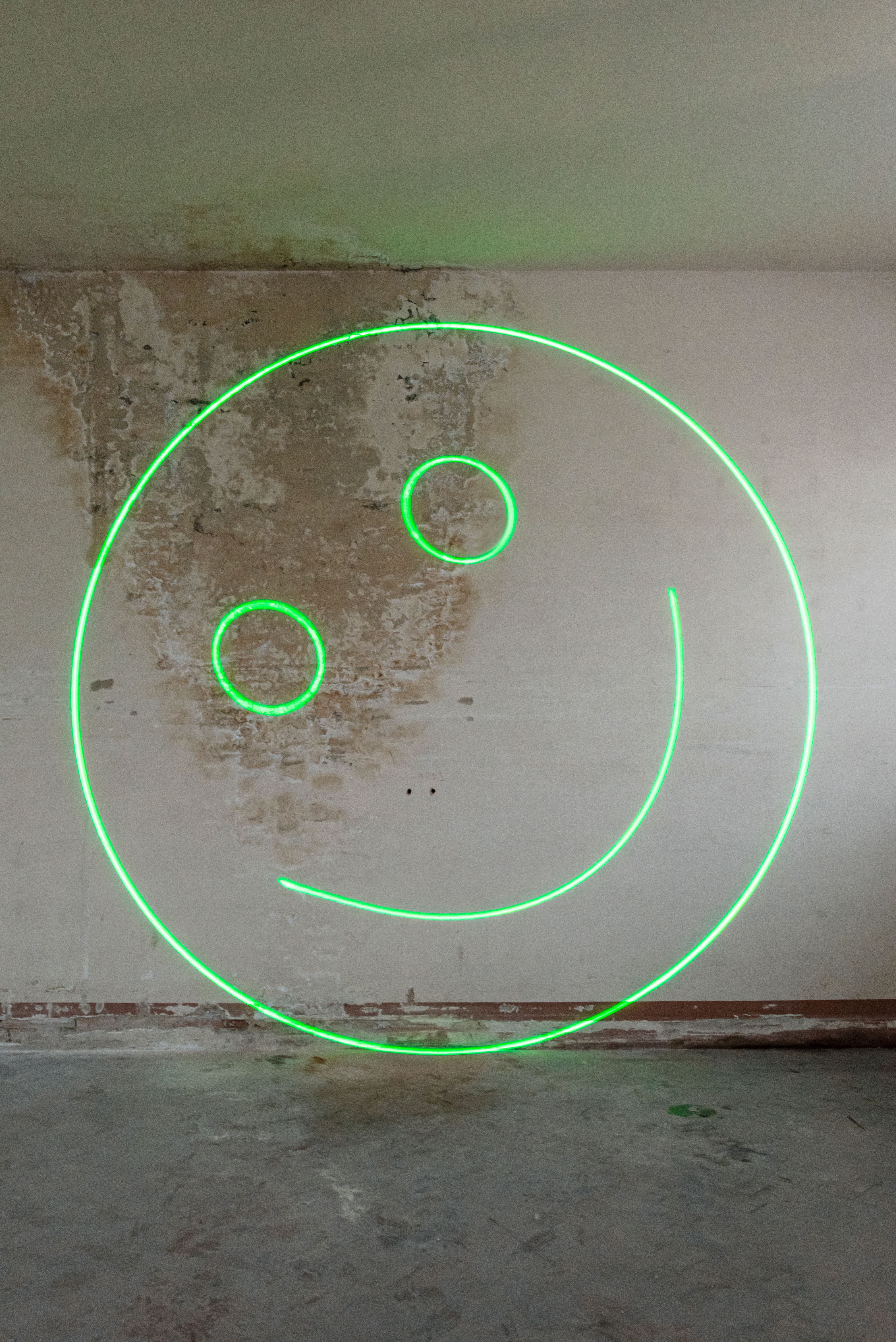 green smiley laser on the wall