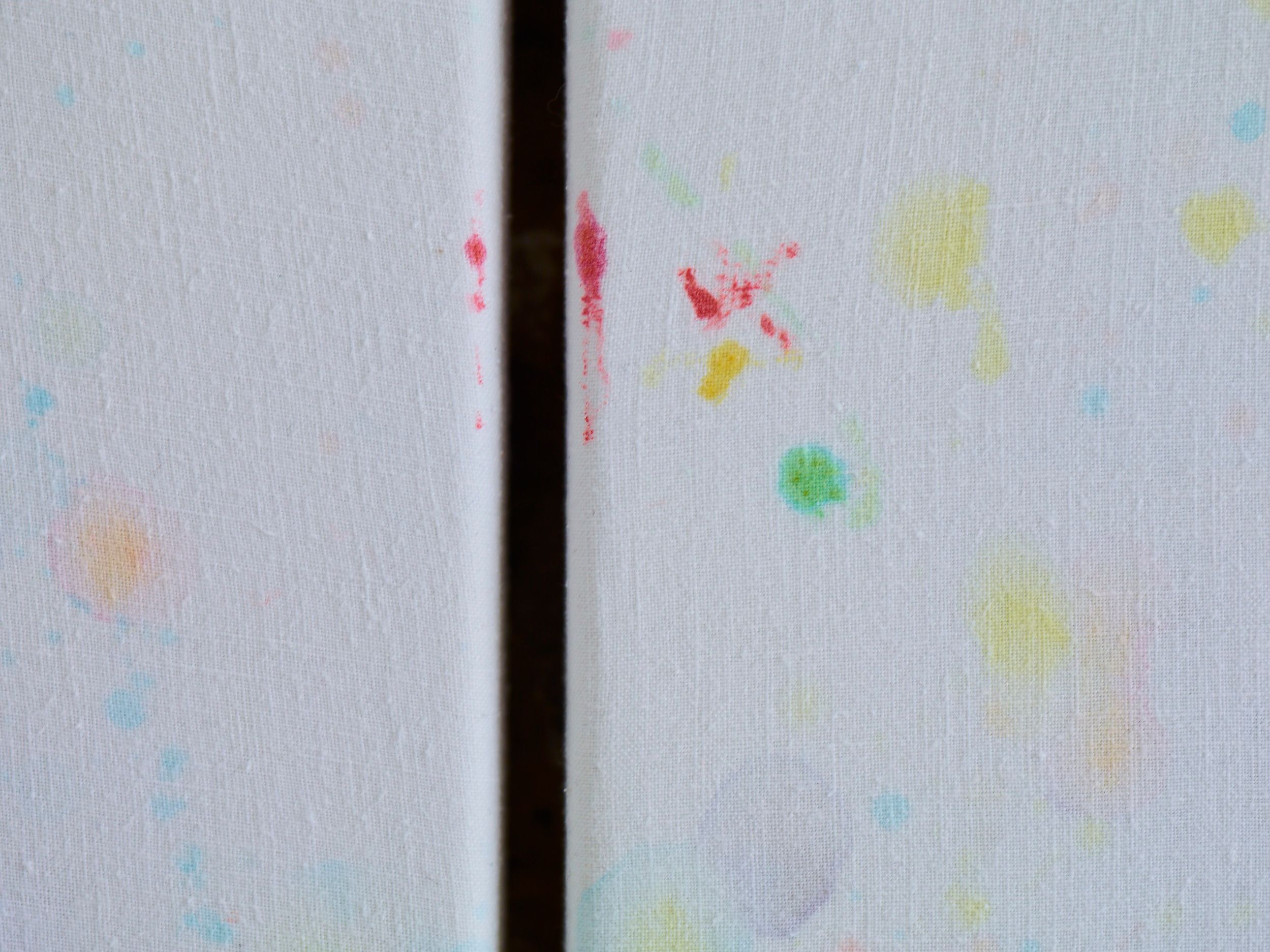Close-up of red, yellow and green stains at the join between two sheets