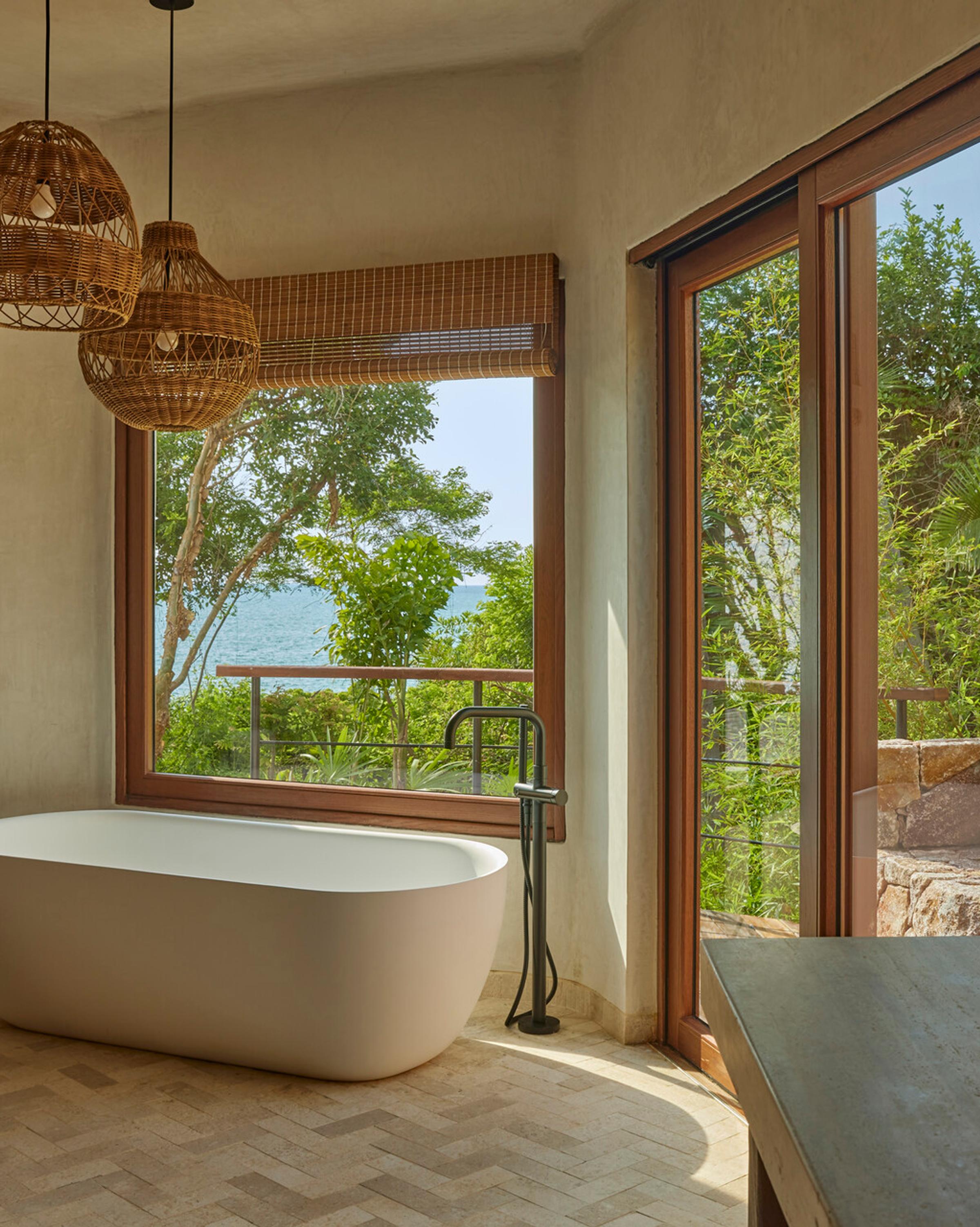 A sophisticated and serene interior featuring natural materials, local artisan decor, and large windows that invite the surrounding nature indoors.