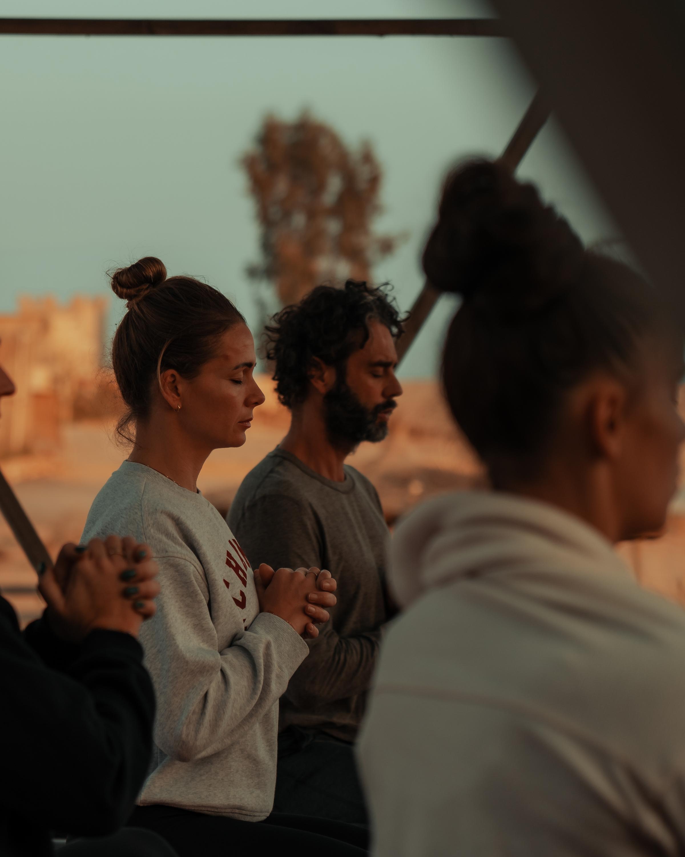 Surfer riding a wave at sunset, immersed in the ocean's flow.