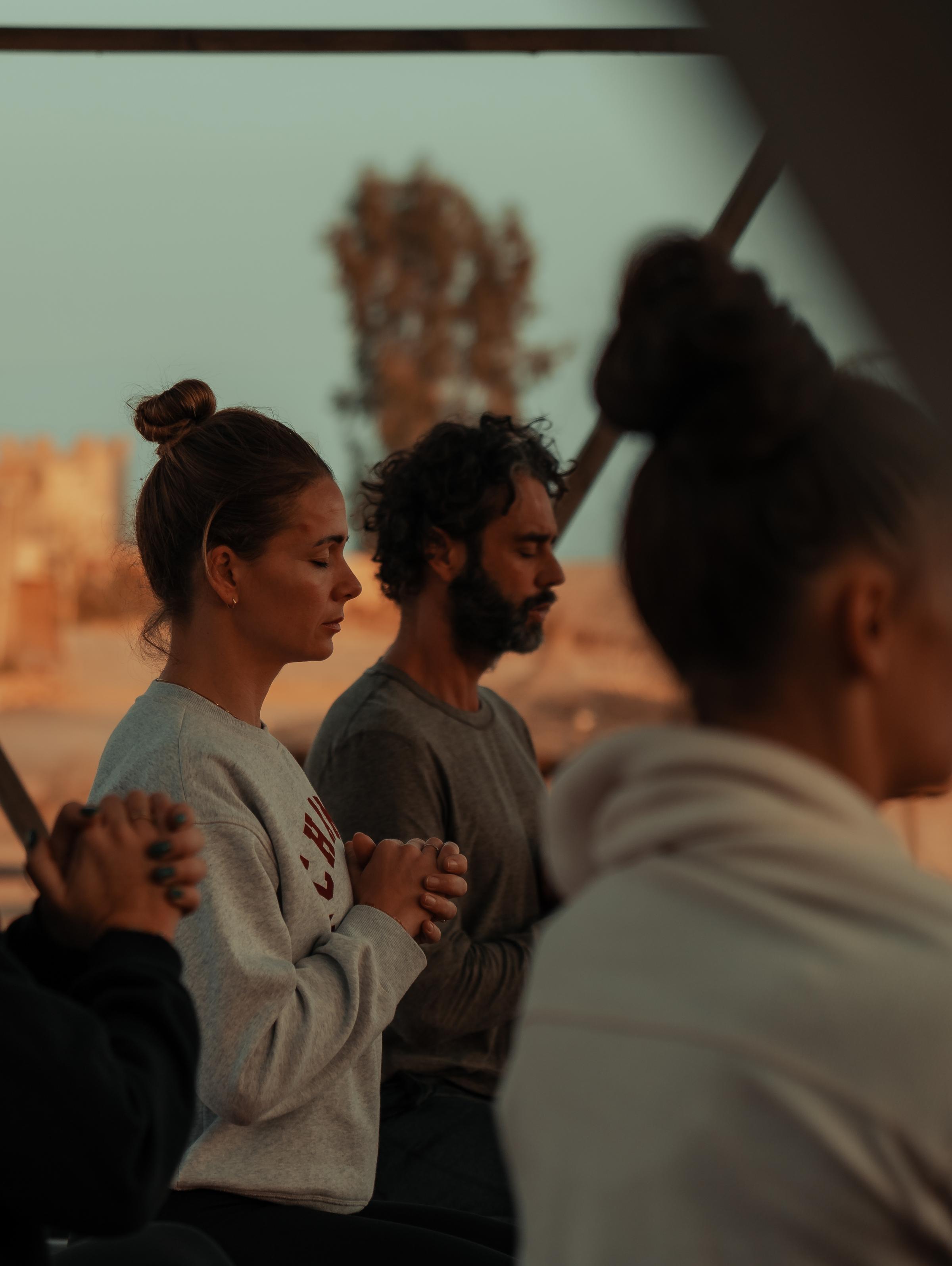 Surfer riding a wave at sunset, immersed in the ocean's flow.