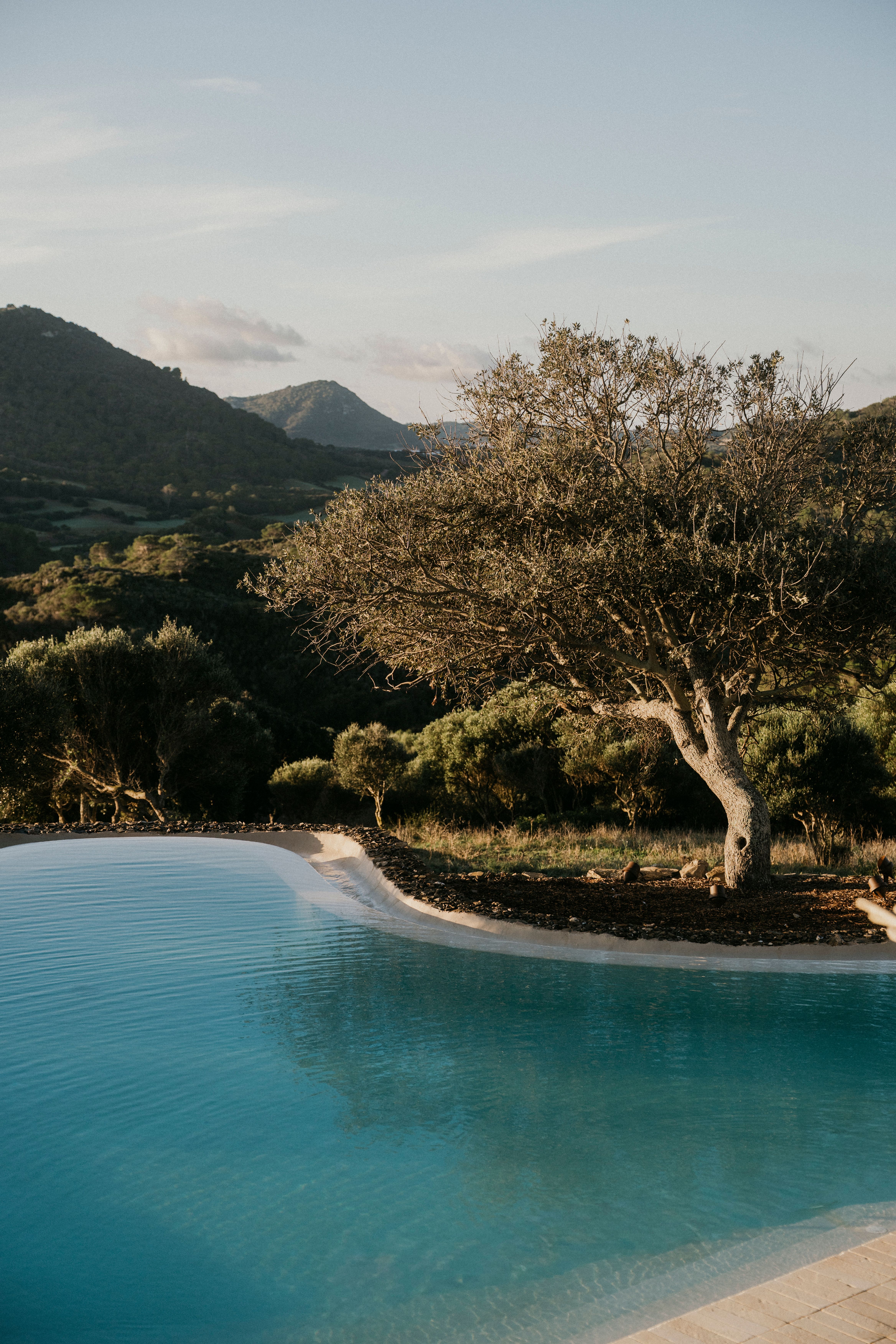 A Menorca landscape with a hint of yellow in the sky, with the infinity pool in the middle.