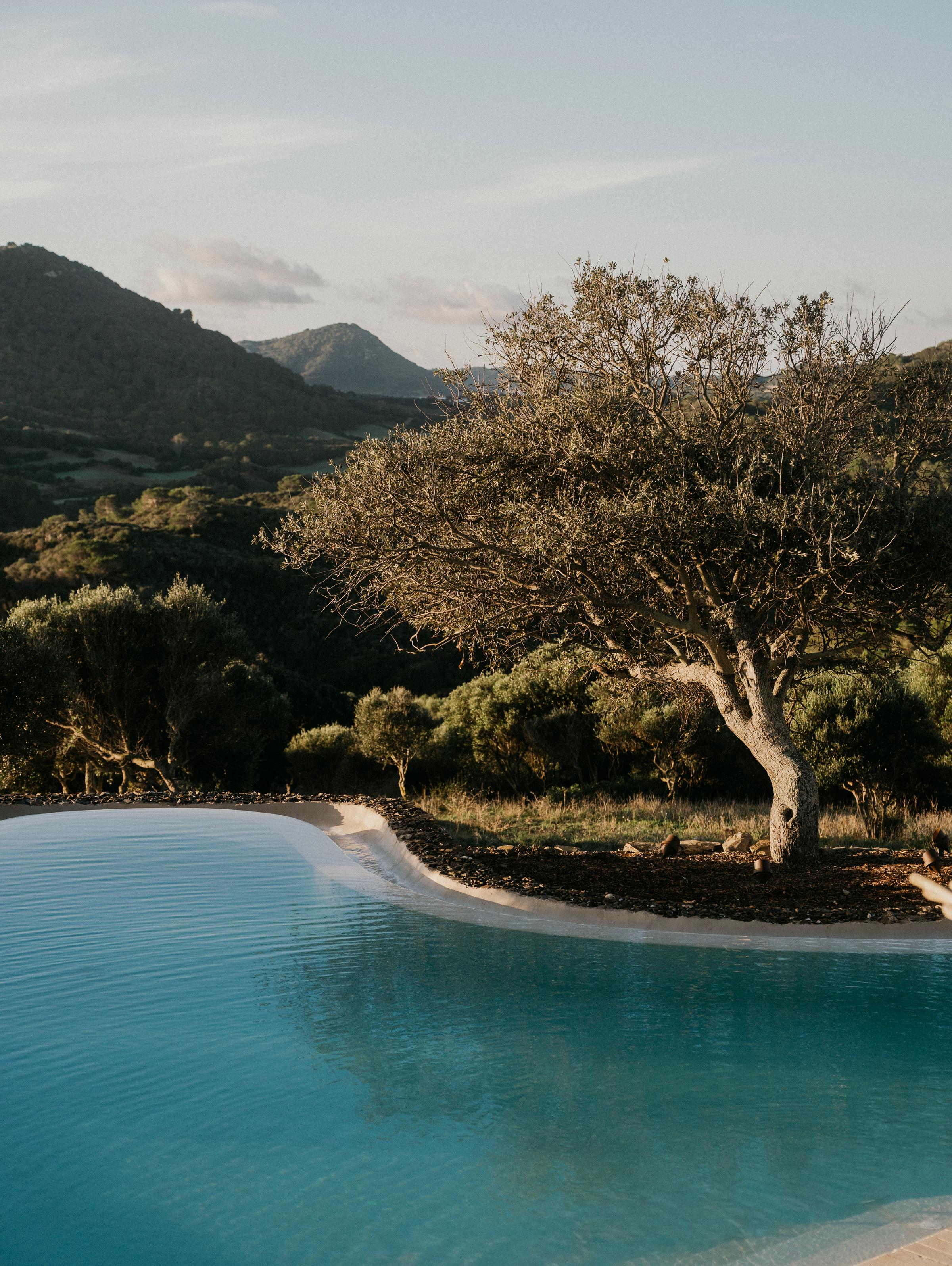 A Menorca landscape with a hint of yellow in the sky, with the infinity pool in the middle.