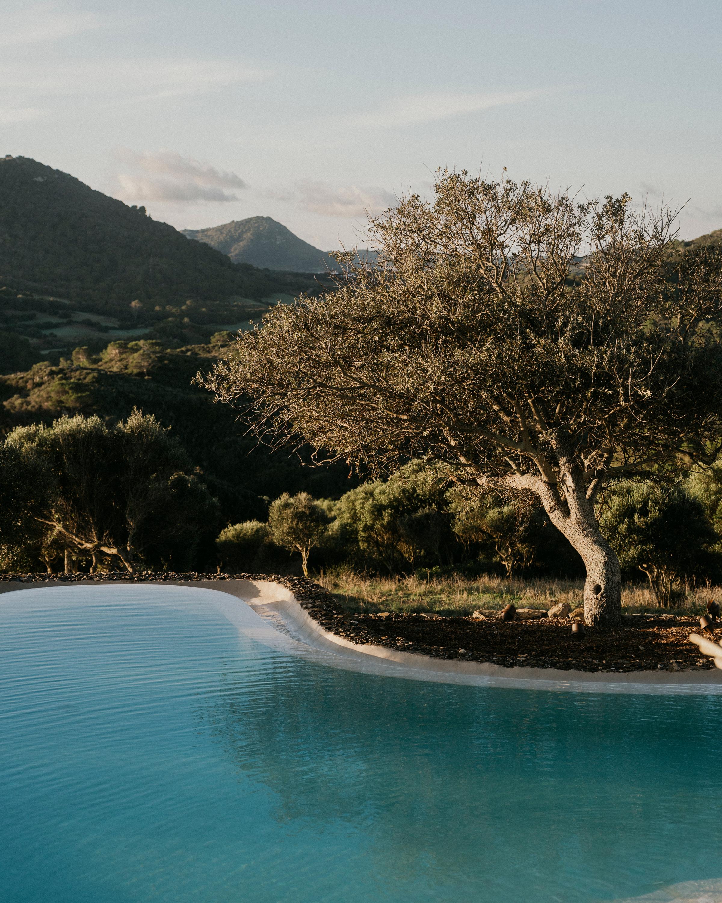 A Menorca landscape with a hint of yellow in the sky, with the infinity pool in the middle.