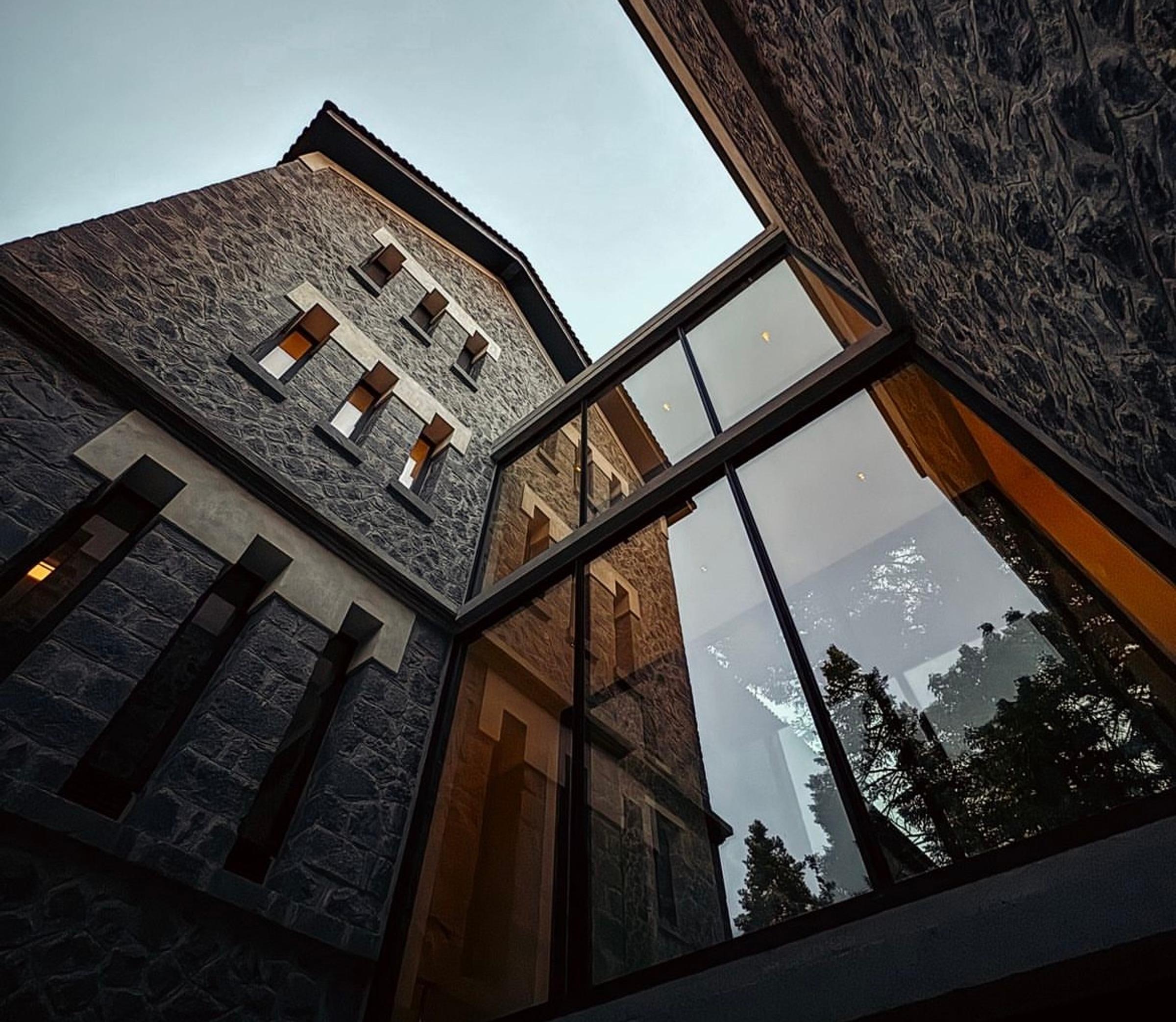 Historic exterior of MANNA, an elegant stone building surrounded by Arcadia's lush forests and serene mountain landscape.