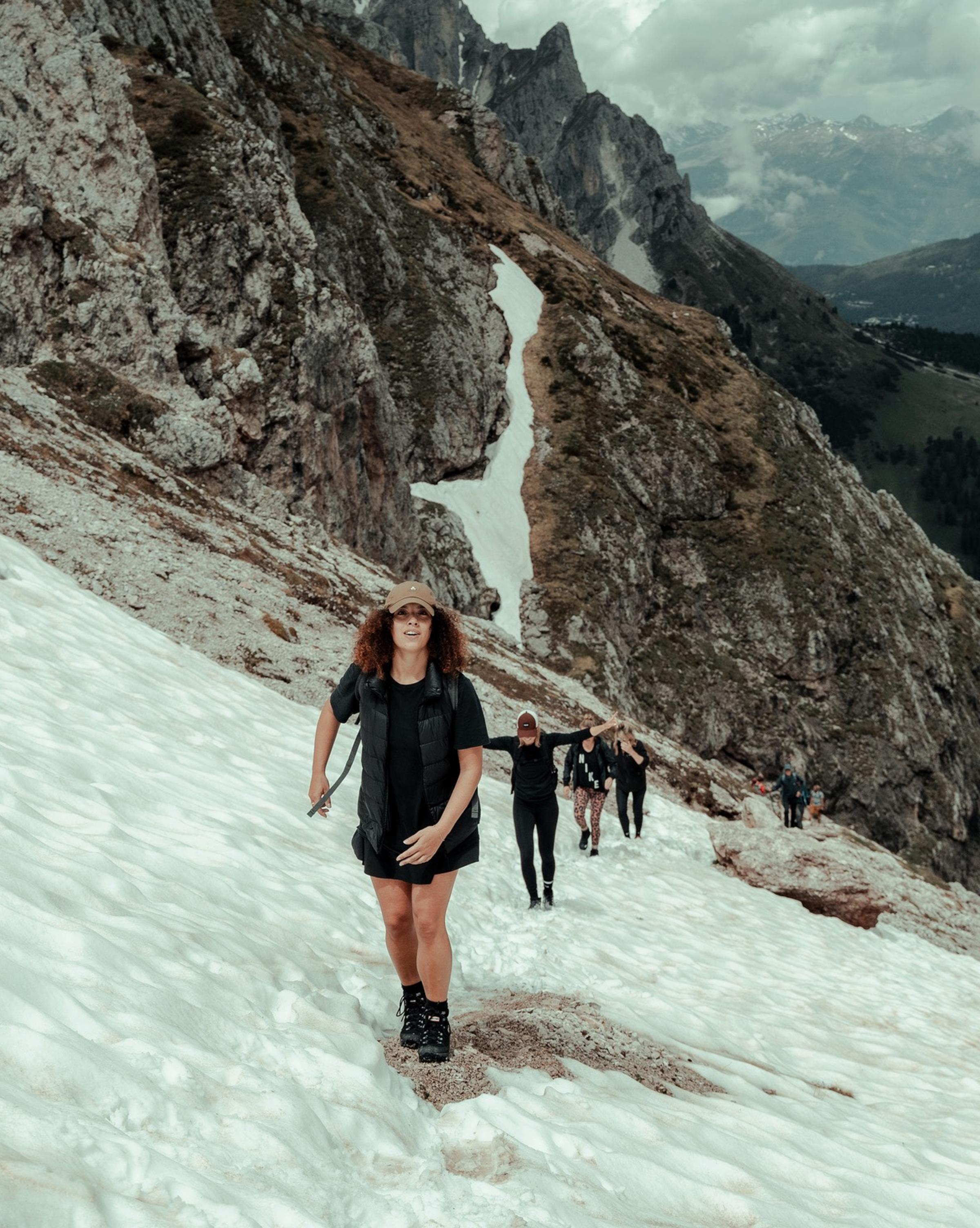 A group of people hiking through a scenic landscape, enjoying nature and the outdoors as they embark on a journey of exploration and teamwork.
