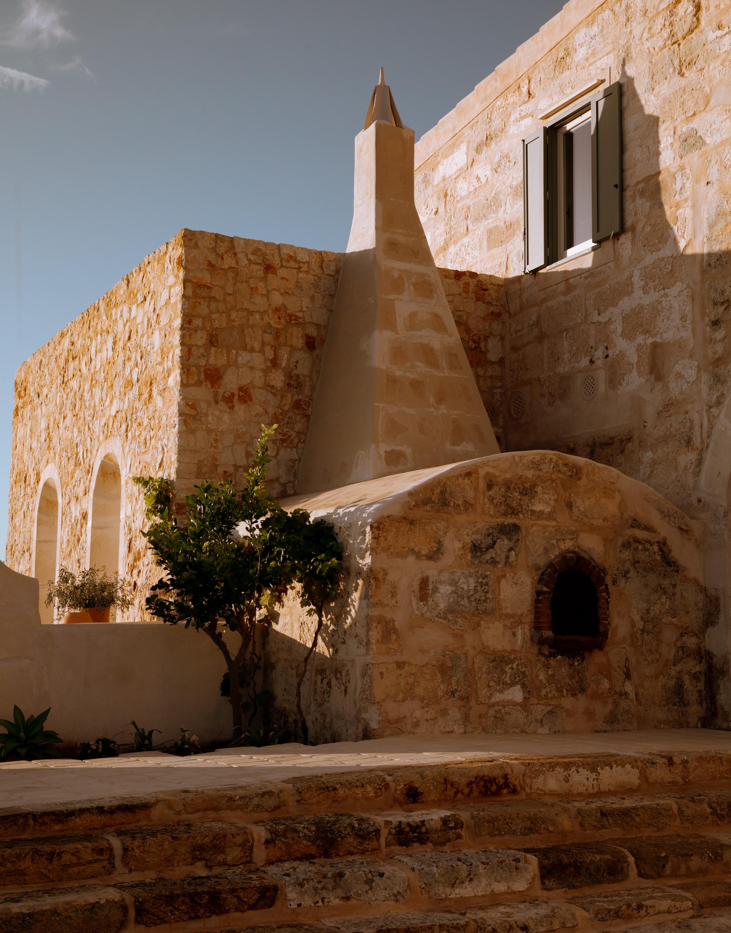 Outdoor lounging area at Son Blanc with linen cushions, shaded pergola, and views of Menorca’s untouched countryside