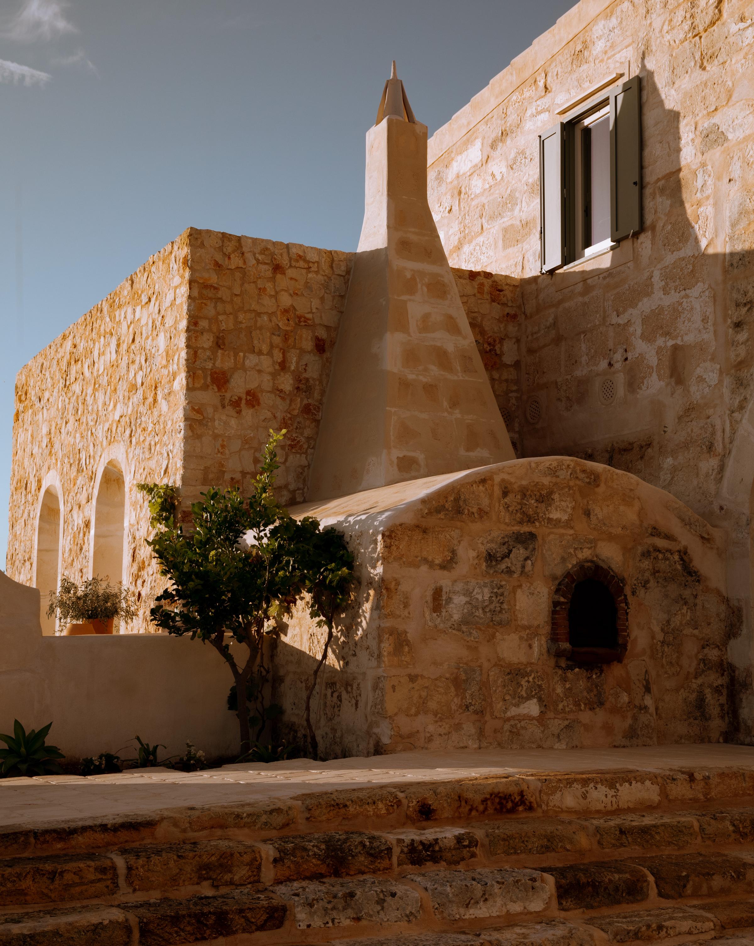 Outdoor lounging area at Son Blanc with linen cushions, shaded pergola, and views of Menorca’s untouched countryside