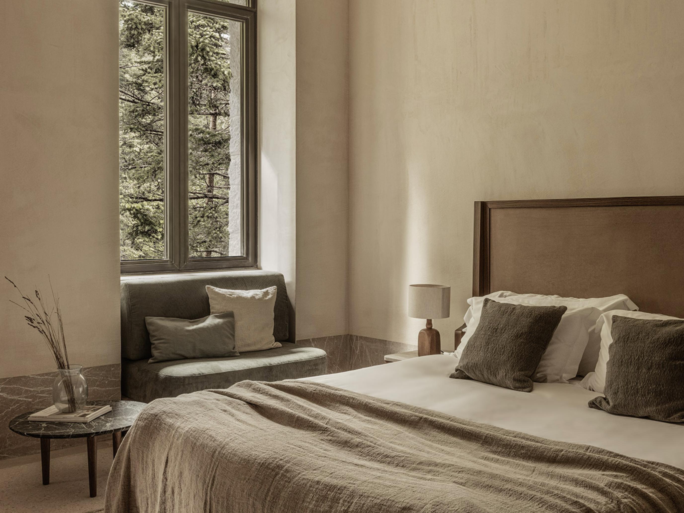 Spacious guest room at MANNA, blending refined comfort with minimalist design and natural elements.