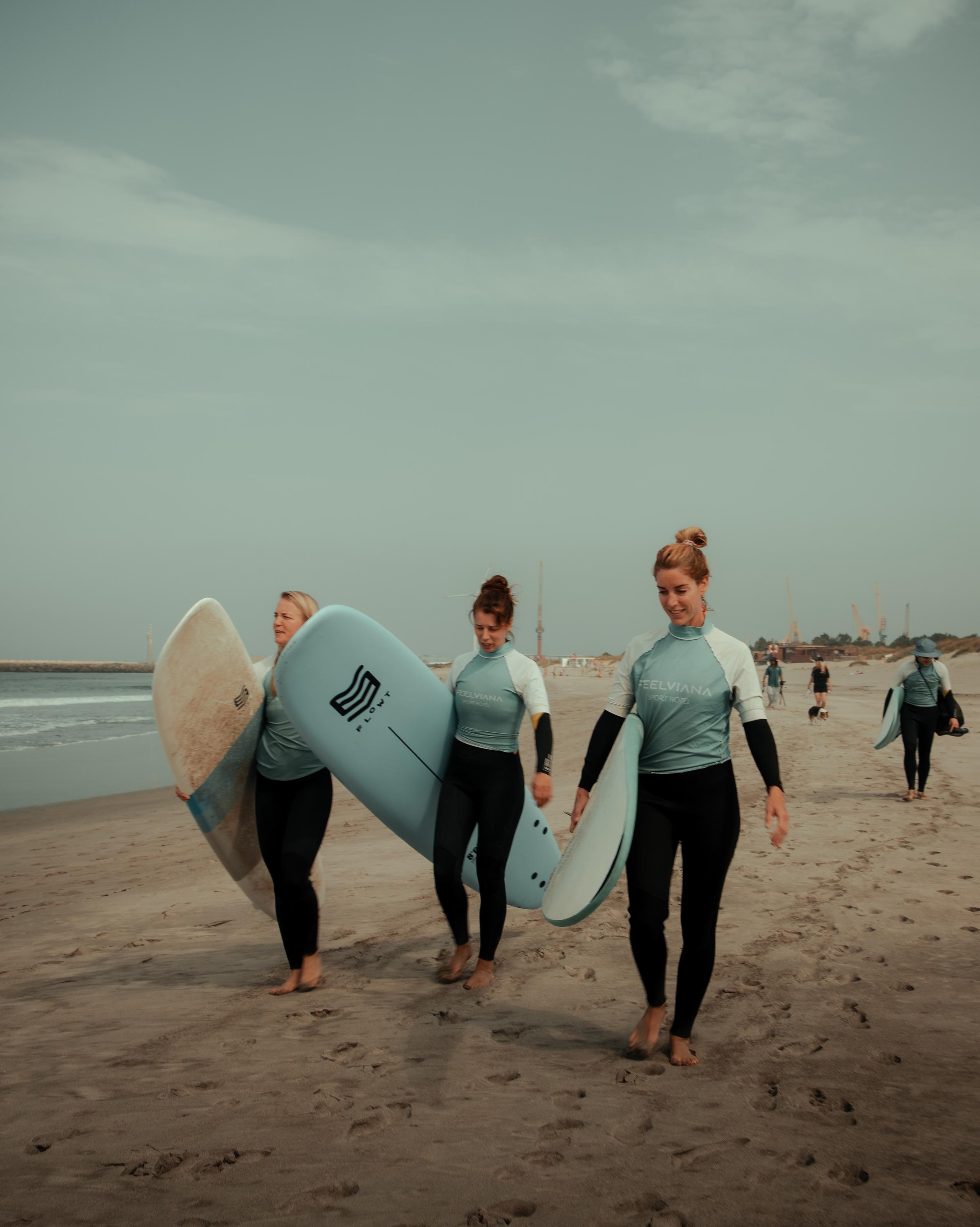 Surfers on the beach, embodying focus, balance, and the spirit of Kaer's transformational experiences