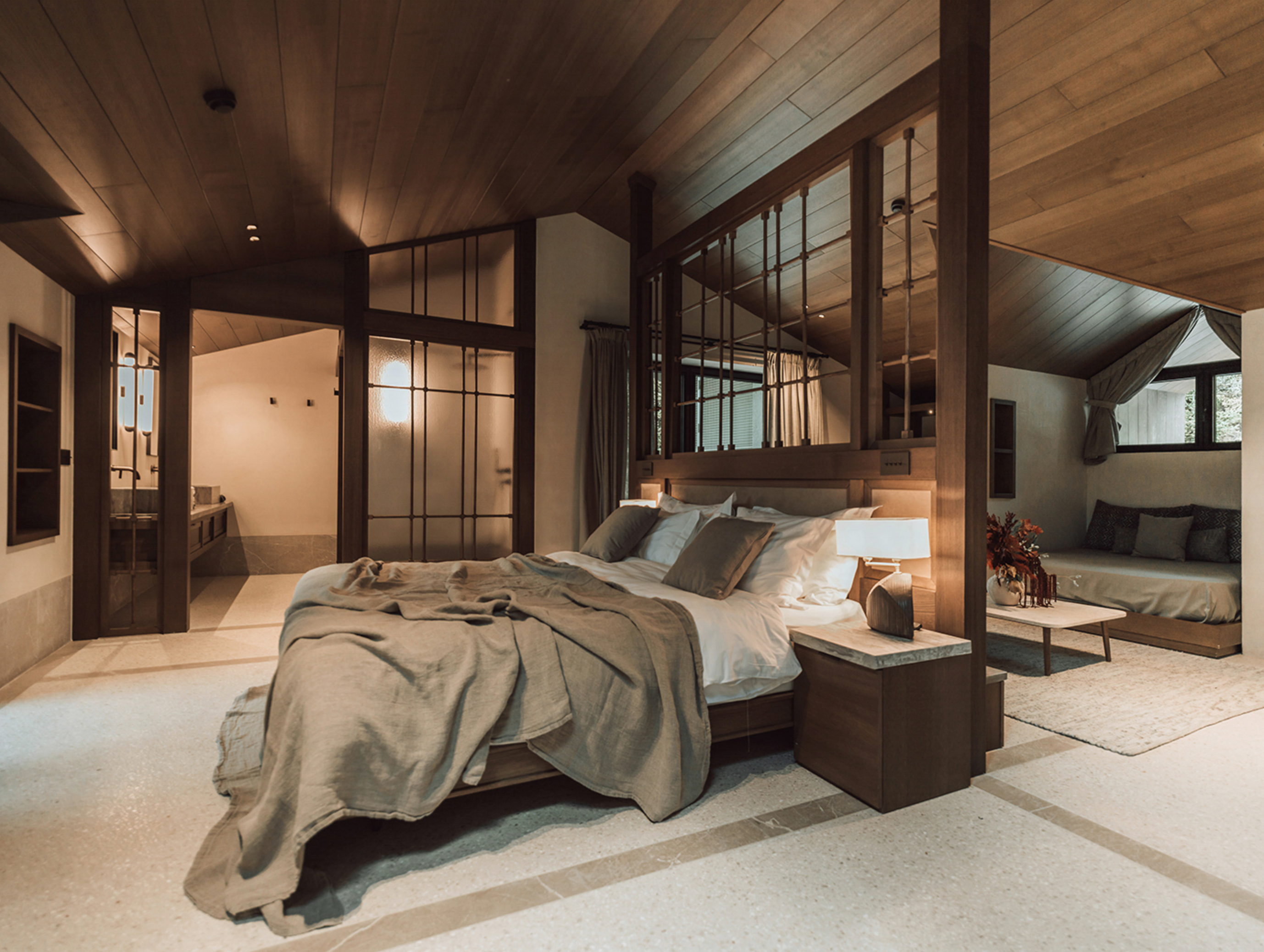 Spacious MANNA Suite showcasing refined luxury, elegant furnishings, and expansive forest views.