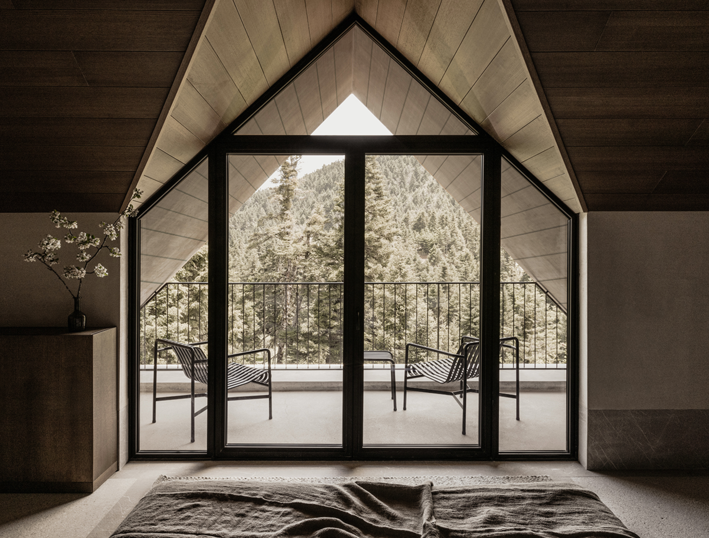 Junior Suite at MANNA, blending minimalist elegance, natural textures, and breathtaking views of the surrounding evergreen forests.