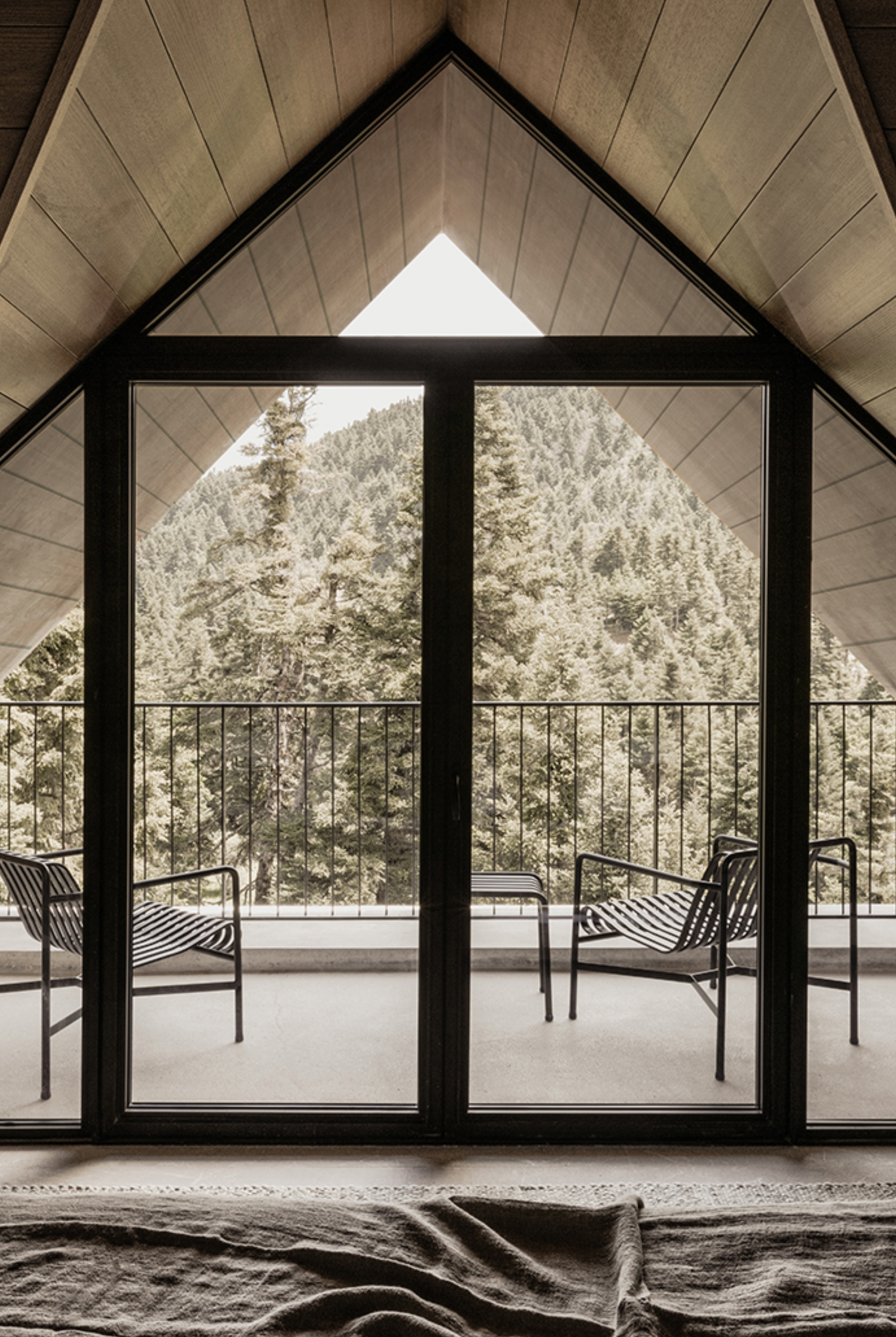 Junior Suite at MANNA, blending minimalist elegance, natural textures, and breathtaking views of the surrounding evergreen forests.