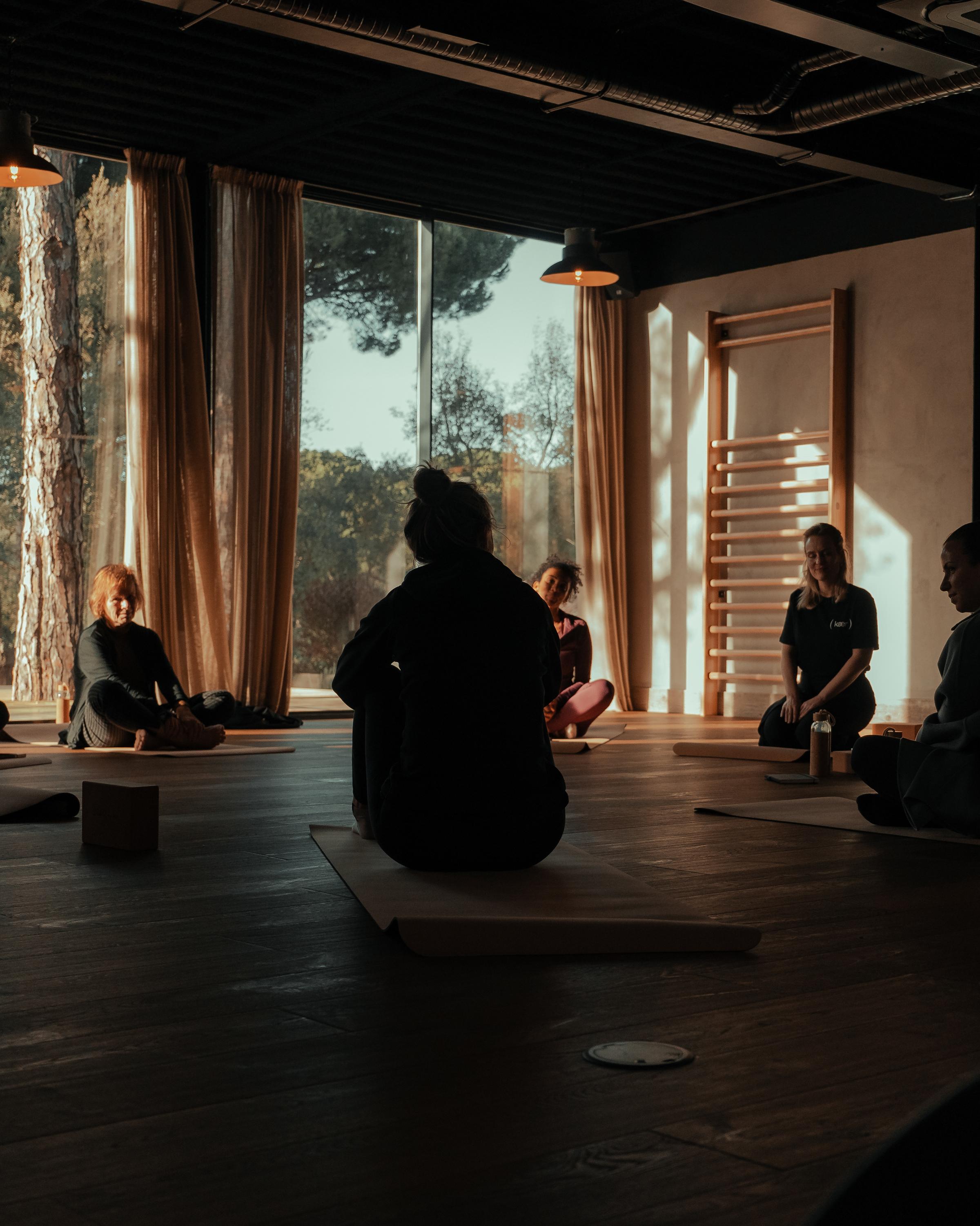 A serene meditation class in progress, with participants seated in a circle, focusing on mindfulness and relaxation in a tranquil environment.