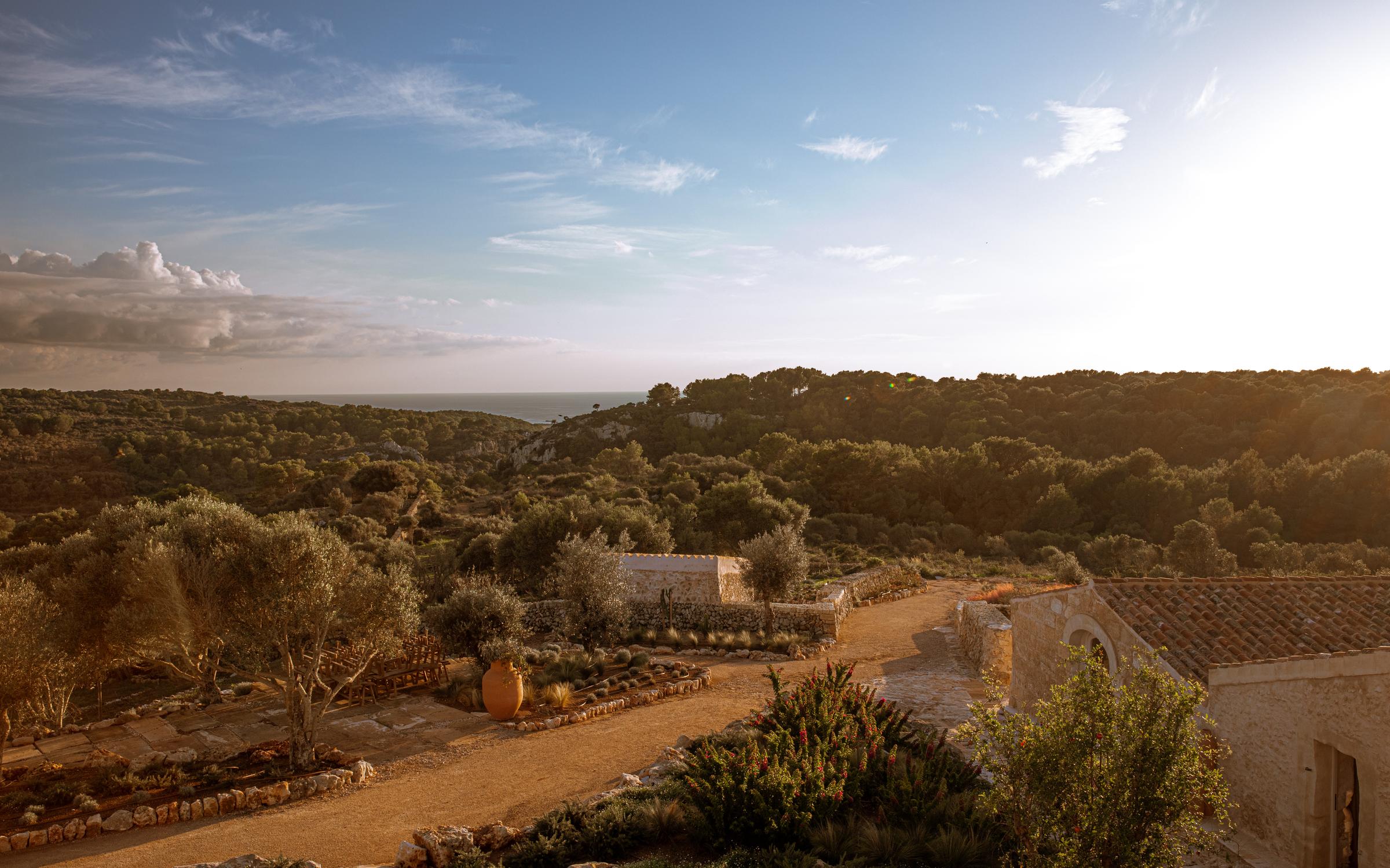 Guests walking barefoot along a dry-stone pathway at Son Blanc, immersed in Menorca’s wild and peaceful landscape
