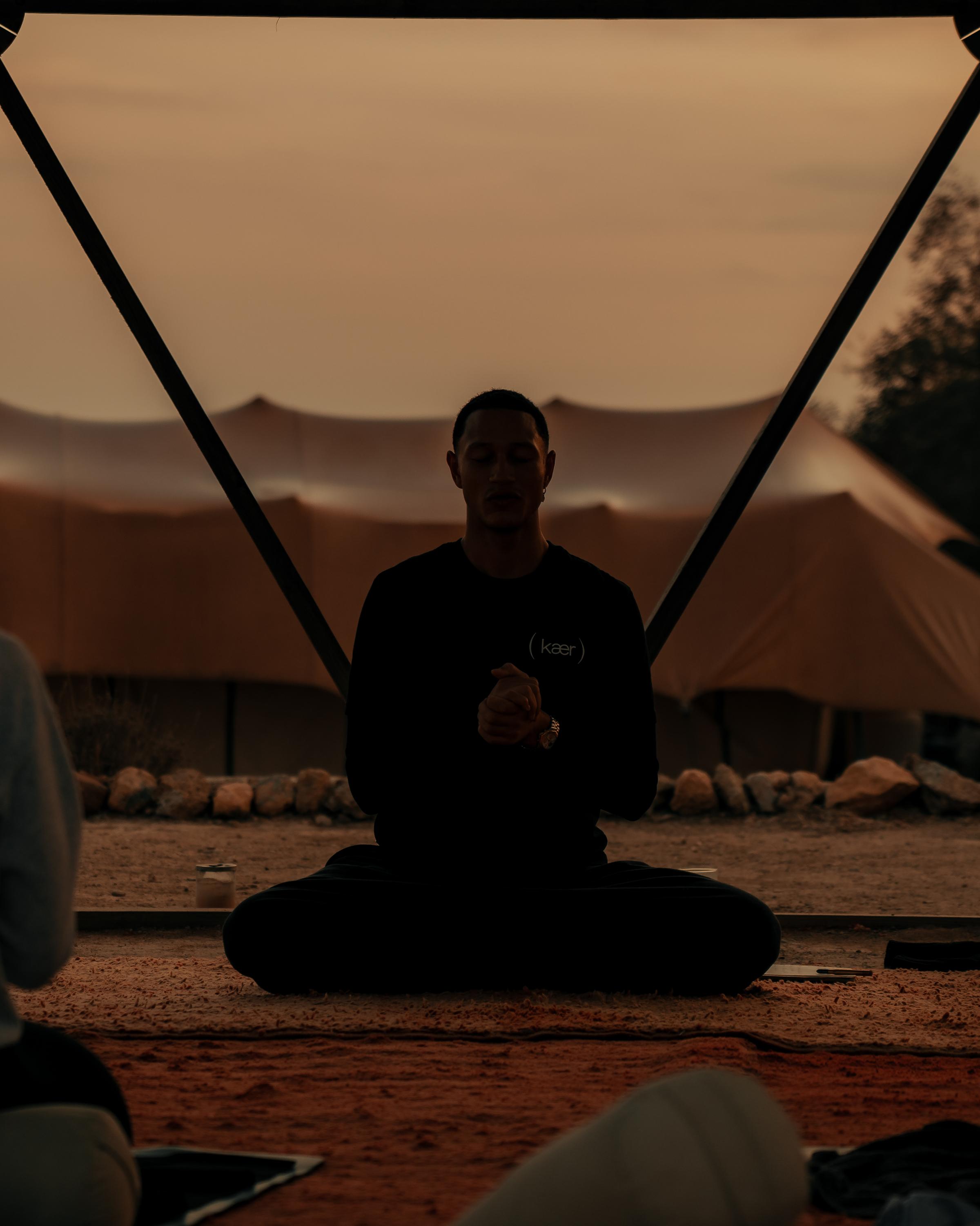 Man sitting in meditation at sunrise, embracing stillness and a peaceful start to the day.