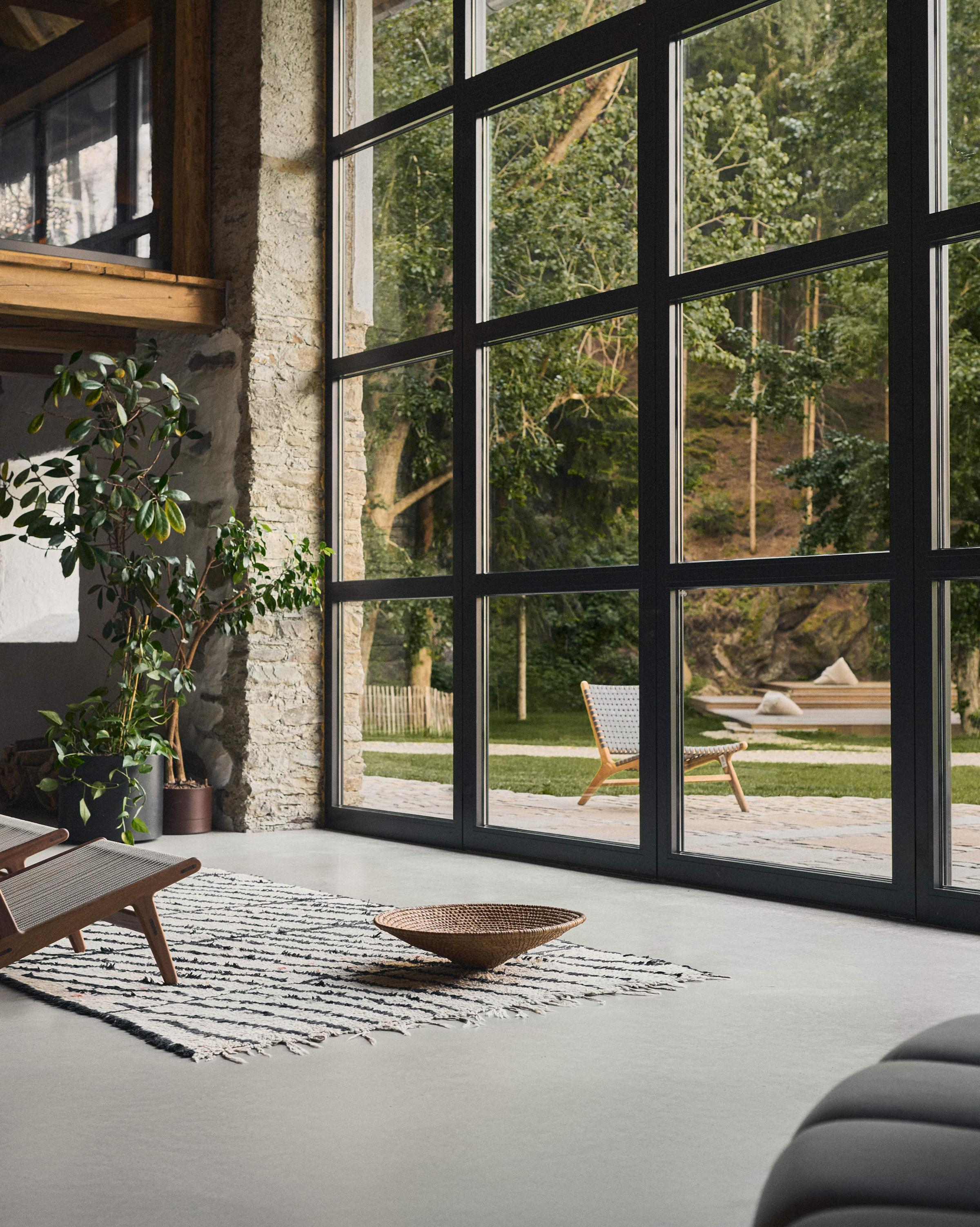 Modern loft-style living space with open fireplace and panoramic windows