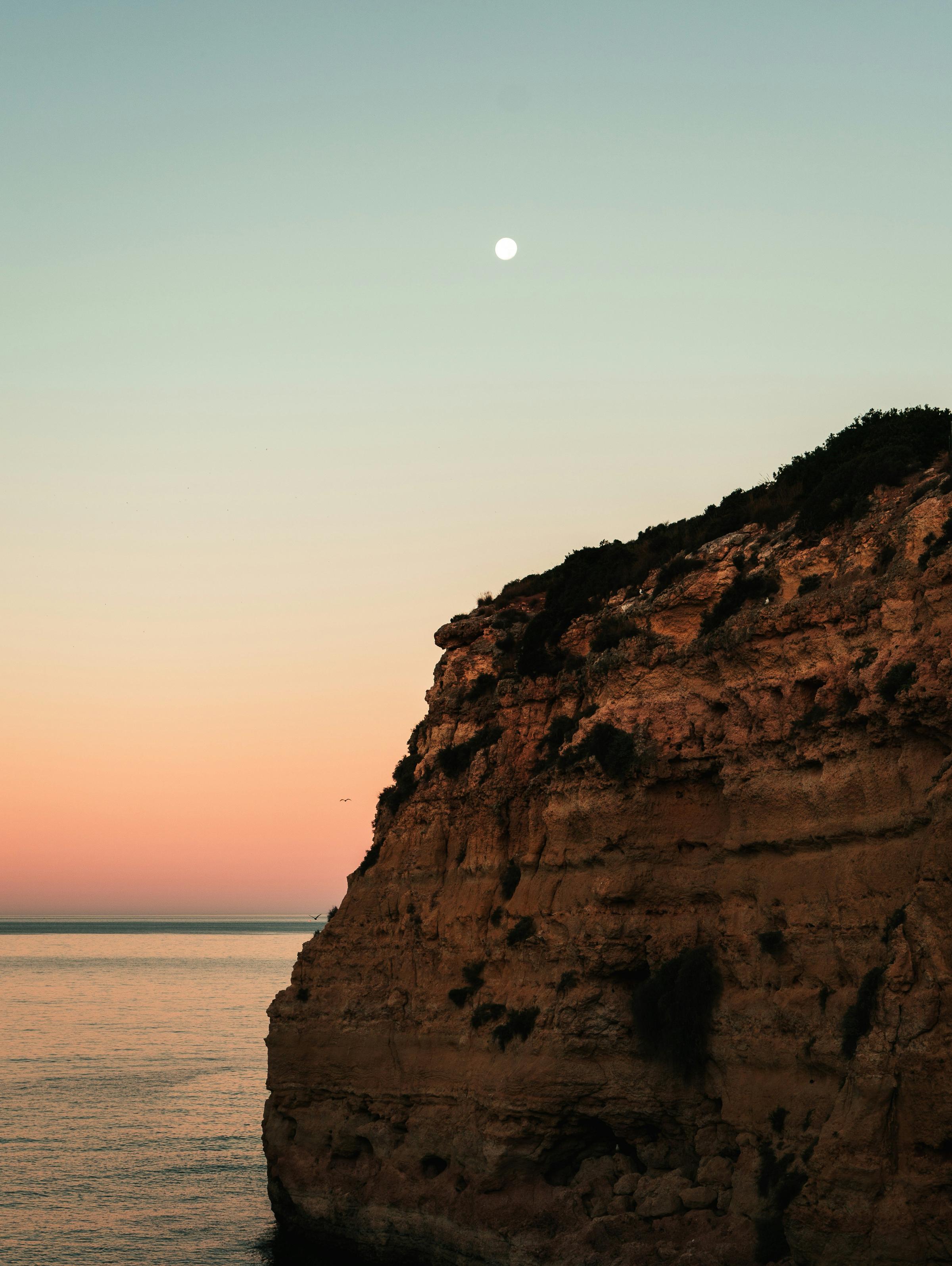 A glowing full moon over calm water, symbolizing feminine energy, intuition, and new beginnings.