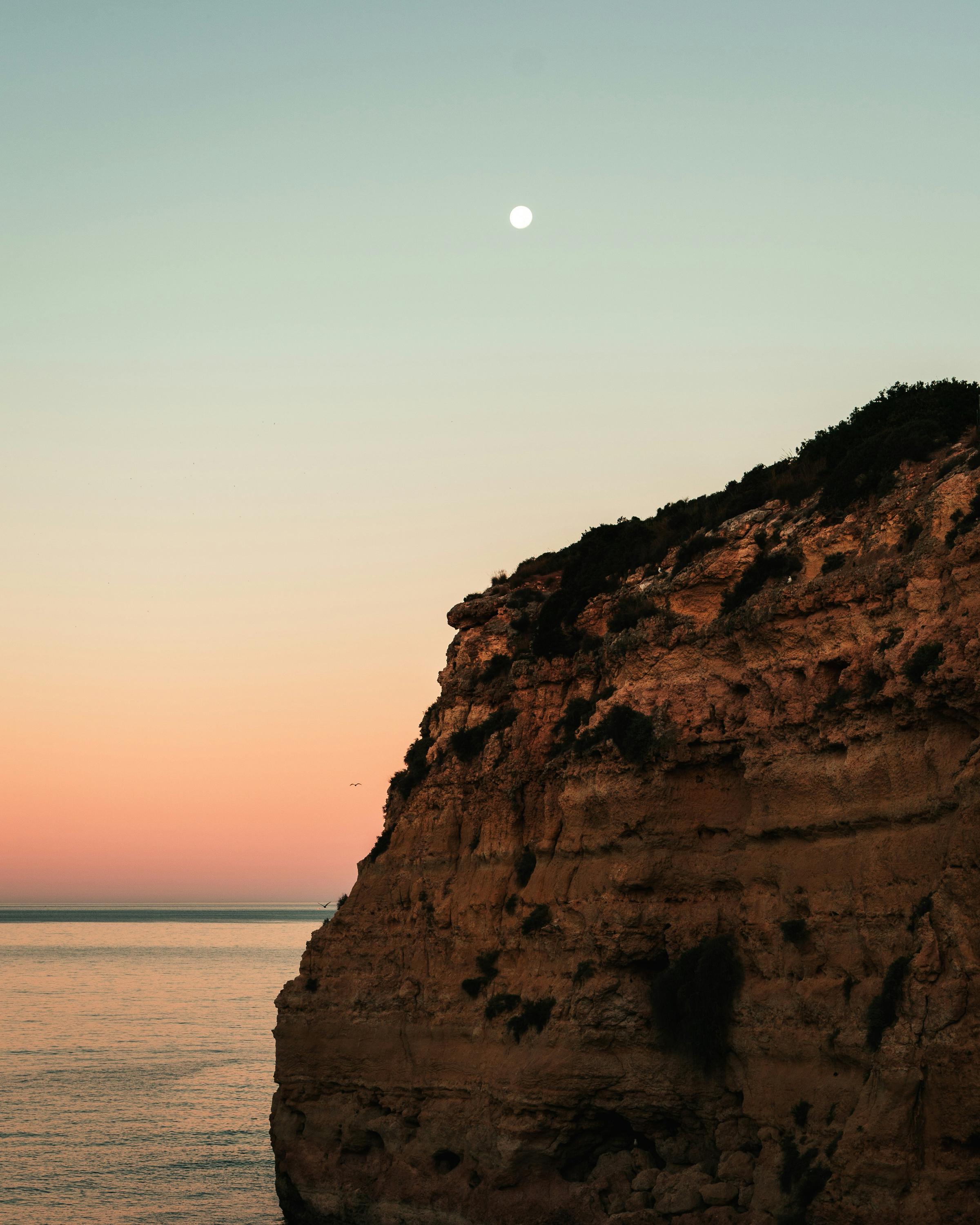 A glowing full moon over calm water, symbolizing feminine energy, intuition, and new beginnings.