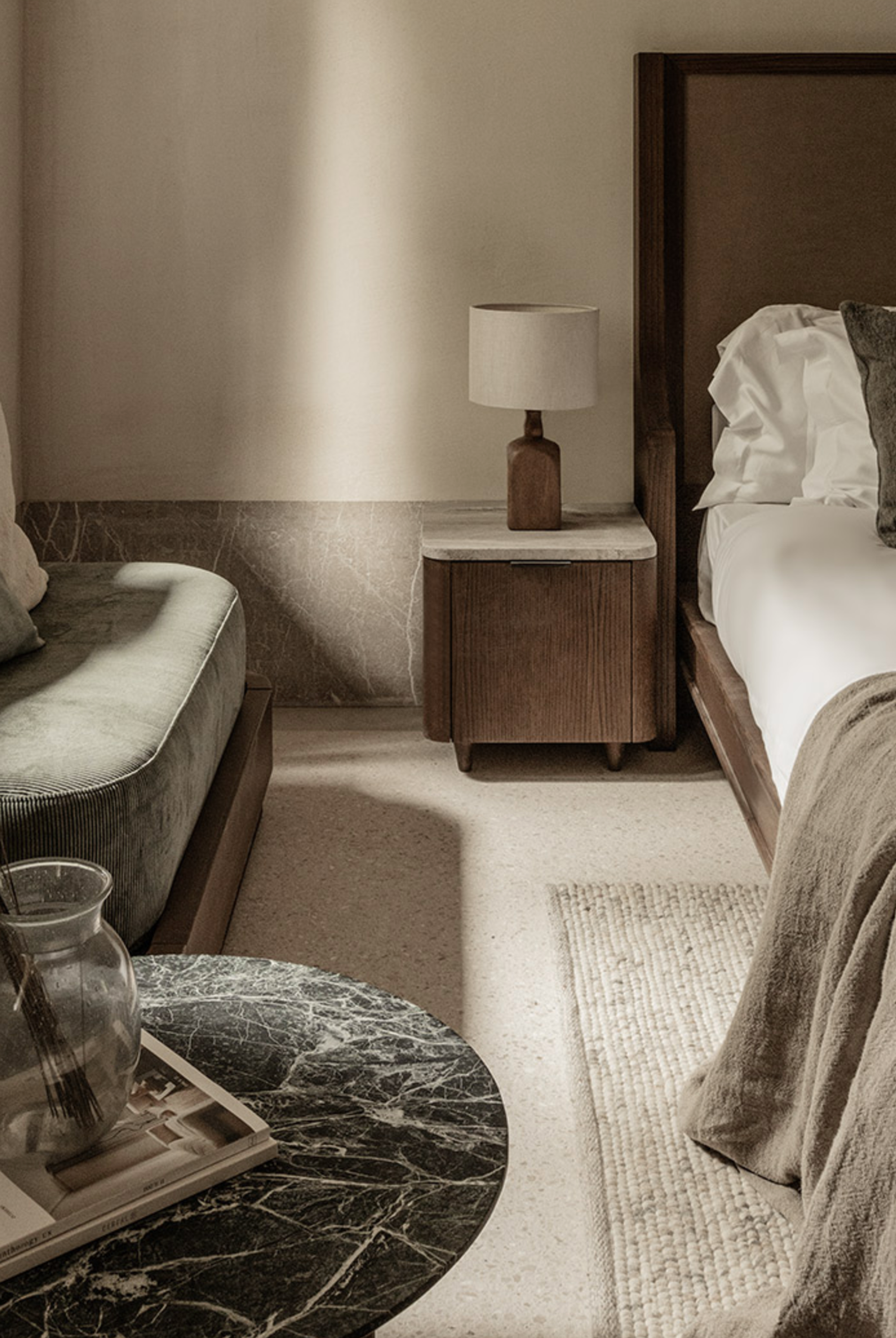 Elegant, cozy suite at MANNA featuring warm, natural tones, luxurious bedding, and tranquil forest views.