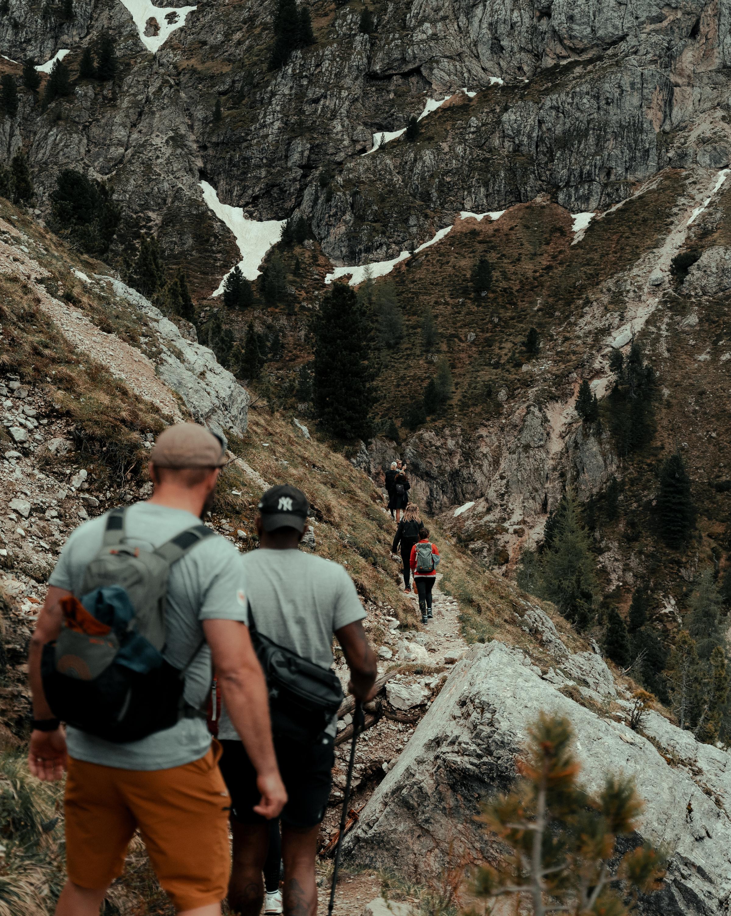 Person hiking along a mountain ridge in the Dolomites, surrounded by dramatic peaks and clear skies, representing mental resilience and personal growth through nature.