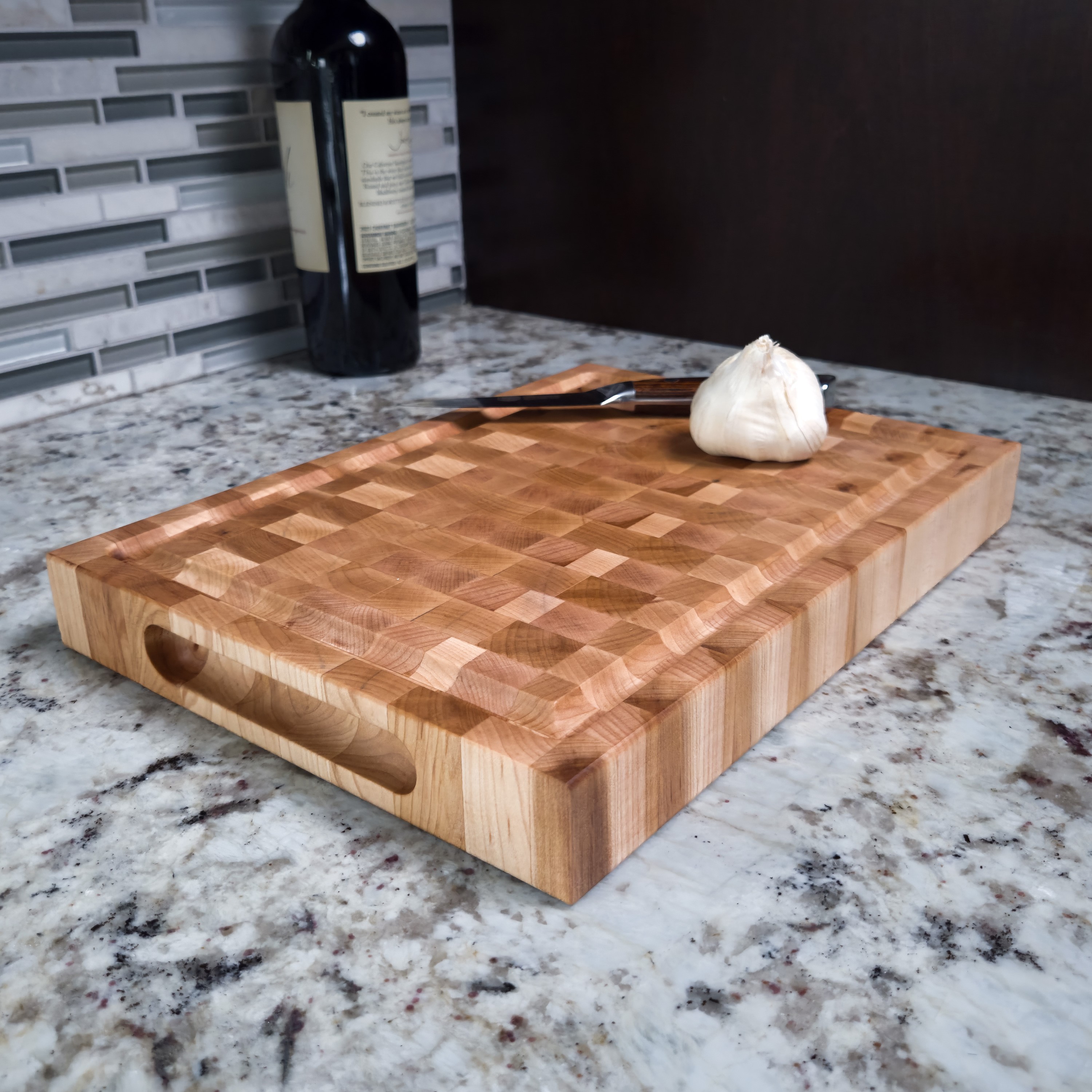 Maple end grain butcher block cutting board with juice groove, on a kitchen counter