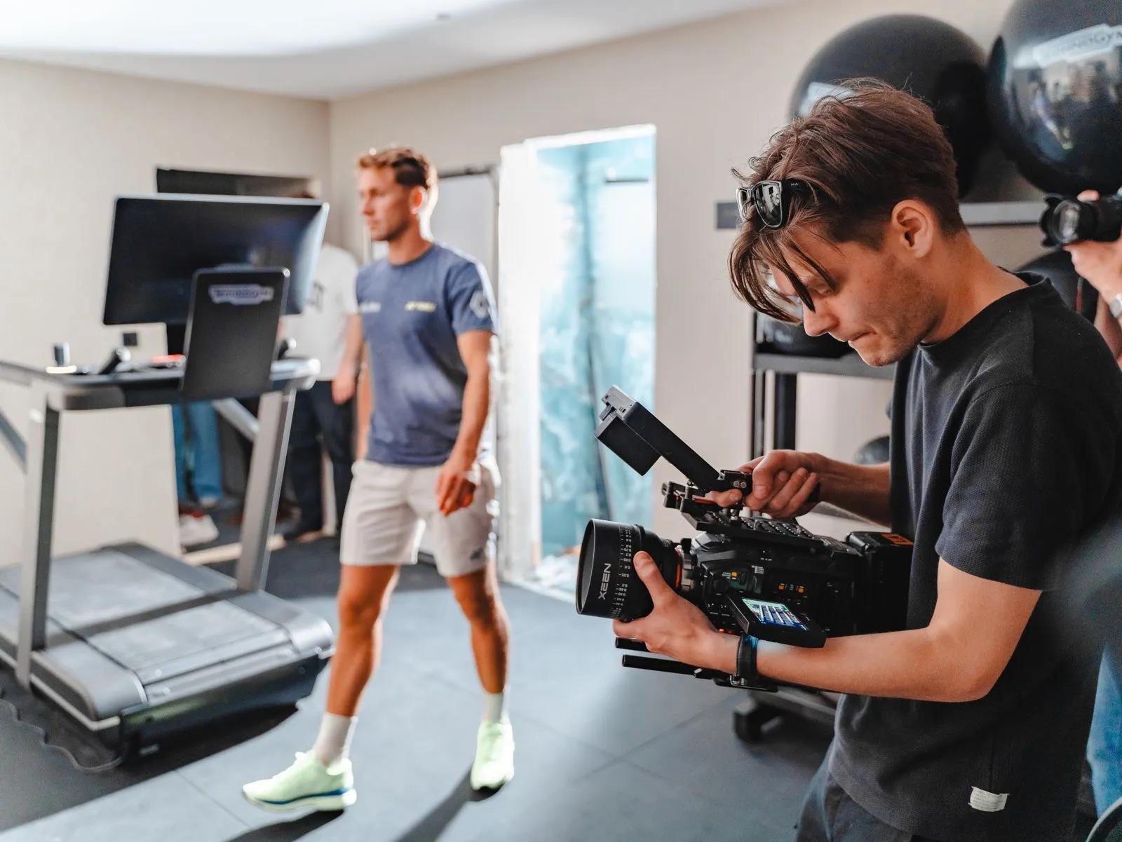 Fotograf filmer en instruktør på et treningssenter