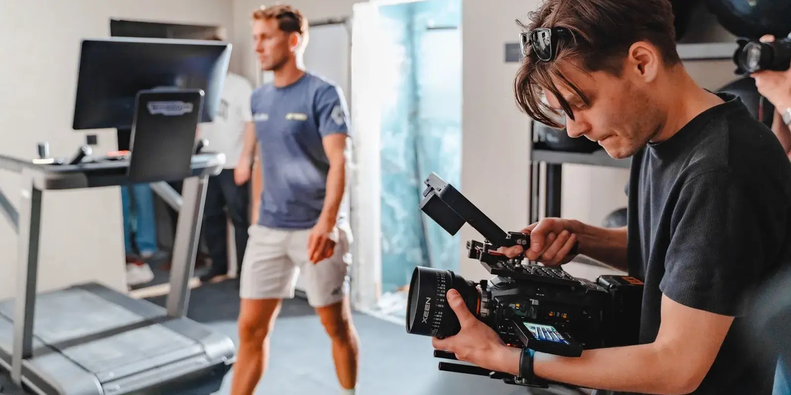 Fotograf filmer en instruktør på et treningssenter