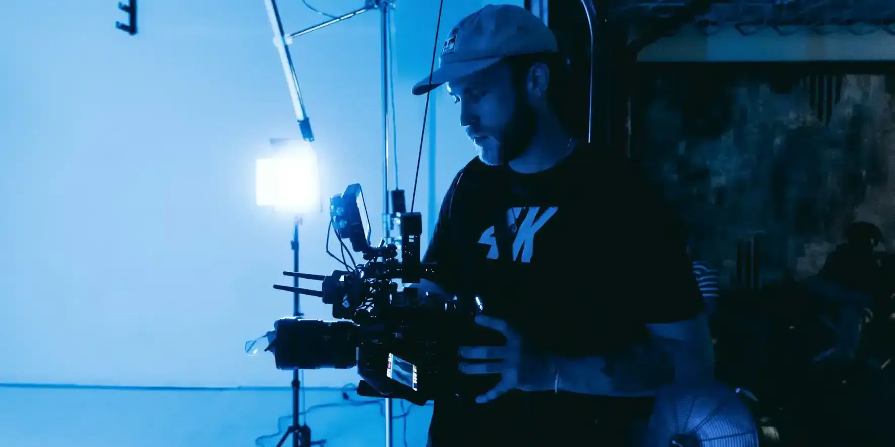 Fotograf med filmkamera i et studio med blått lys