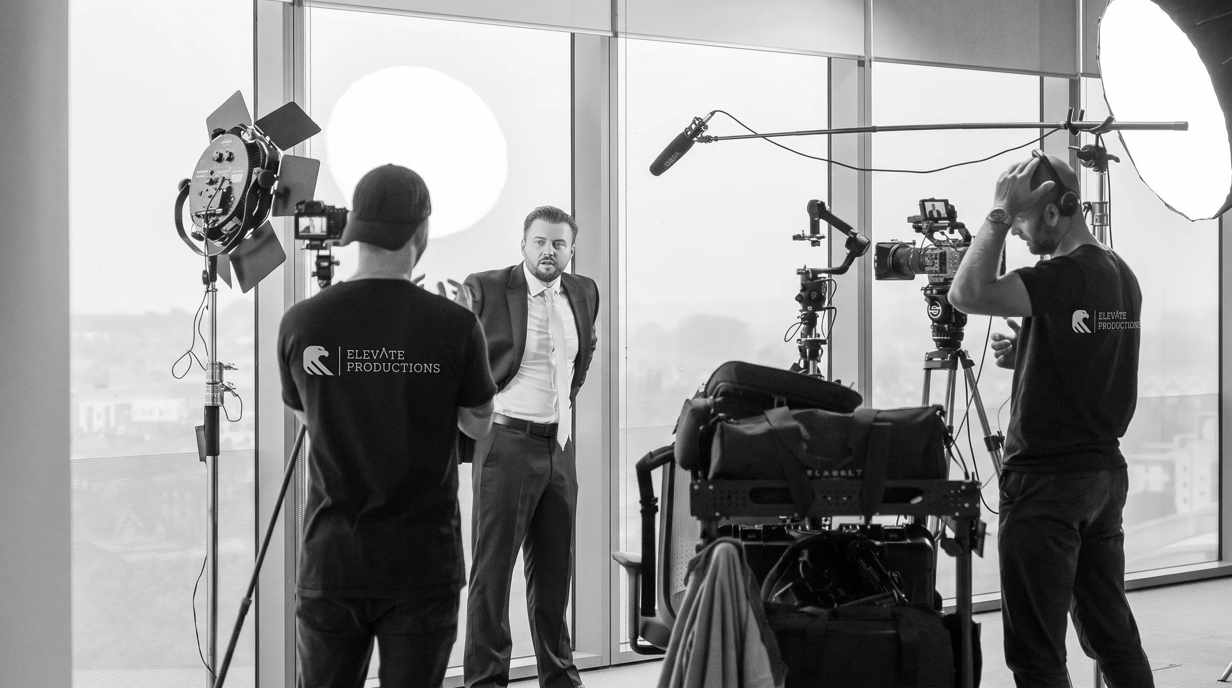 Filmteam rigger lys og kamera til intervju i et lyst lokale