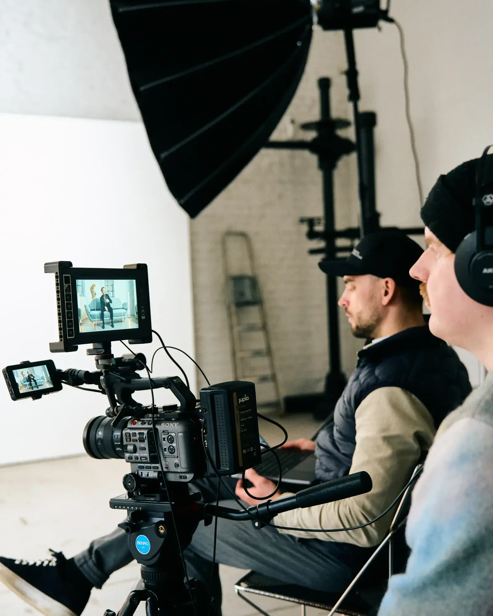 Kameraoperatør og regissør filmer et intervju i et lyst fotostudio