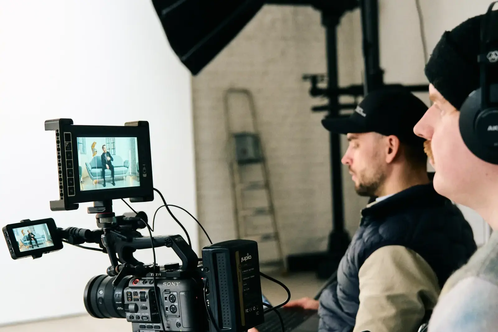 Kameraoperatør og regissør filmer et intervju i et lyst fotostudio