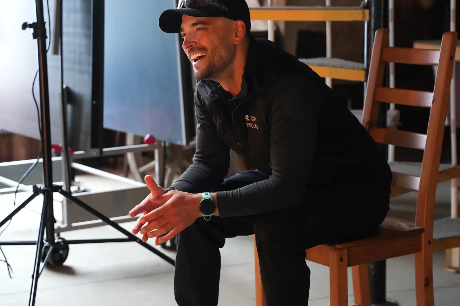 Smilende mann sitter på en stol og snakker under et intervjuopptak