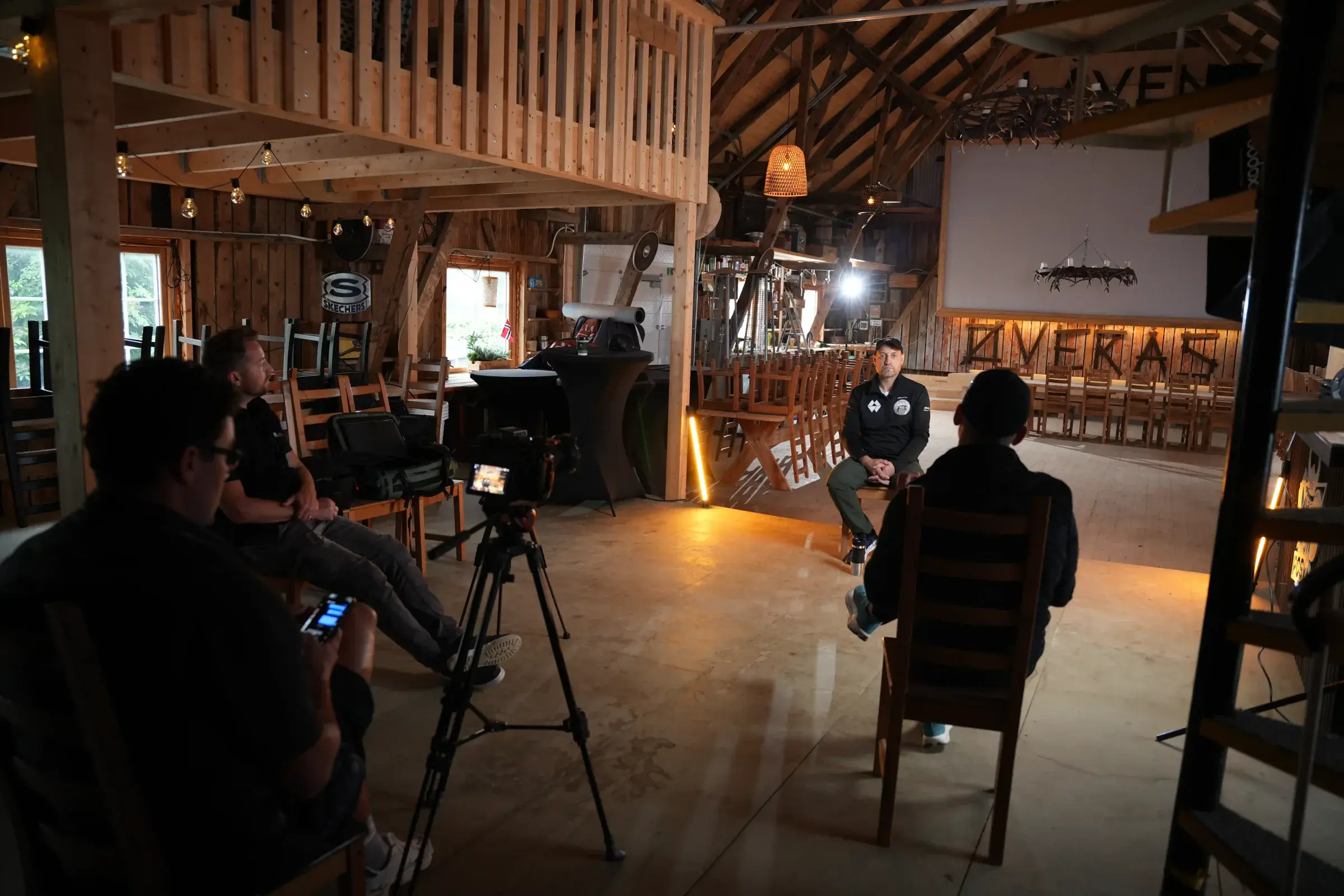 Filmteam følger et intervju i en låve med varmt lys