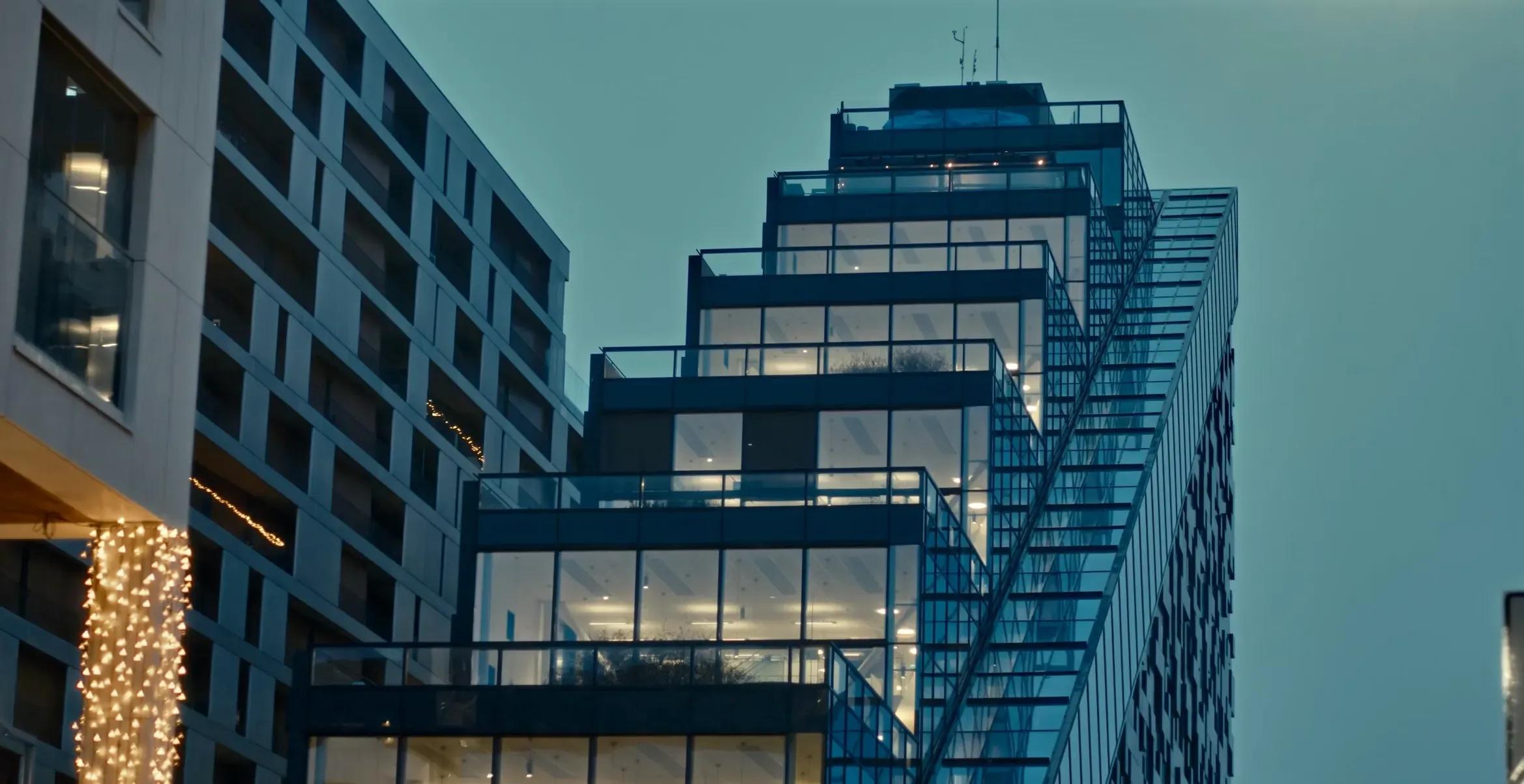 Moderne trappeformet kontorbygg i glass sett nedenfra