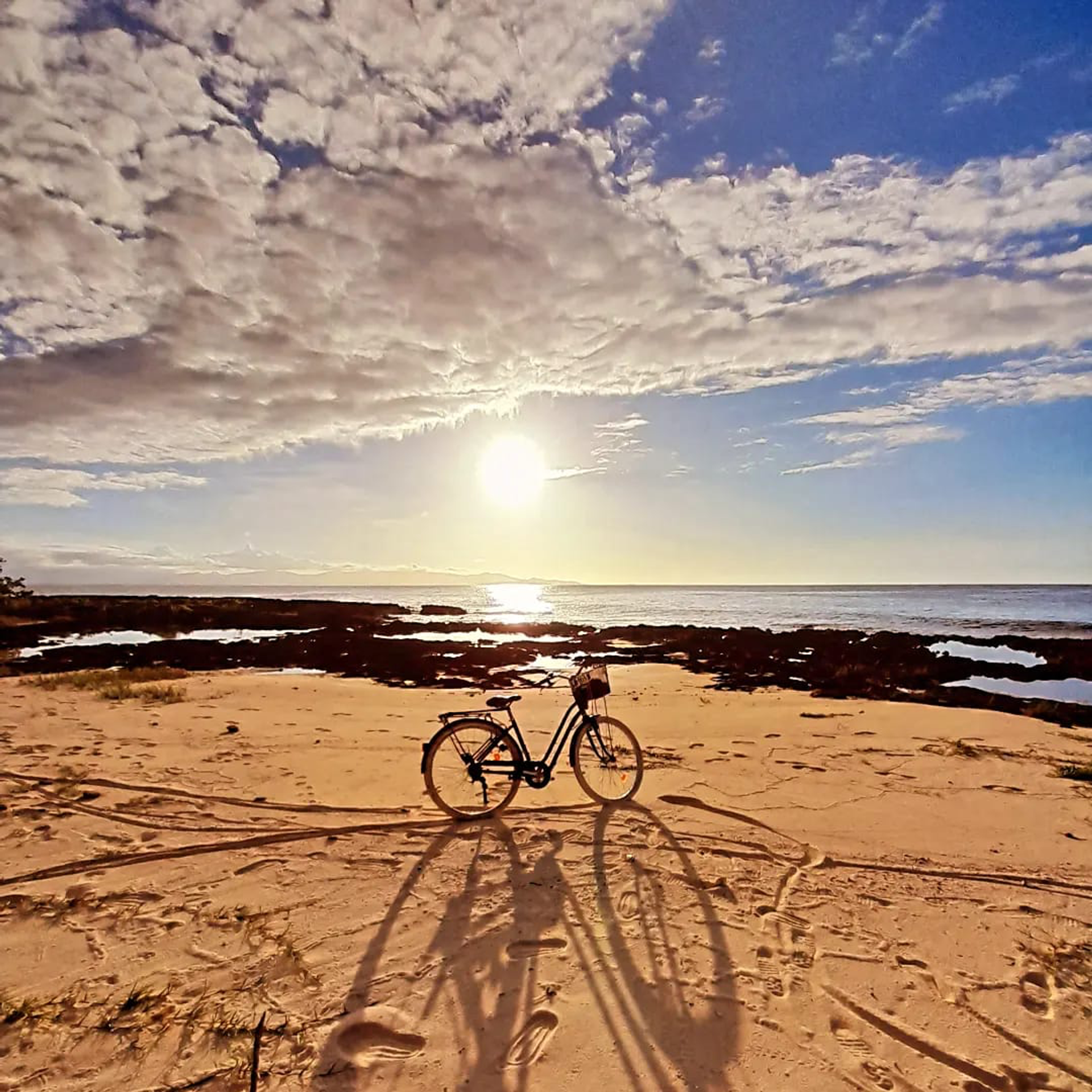 Vélo sur le sable au coucher du soleil à Port-Louis