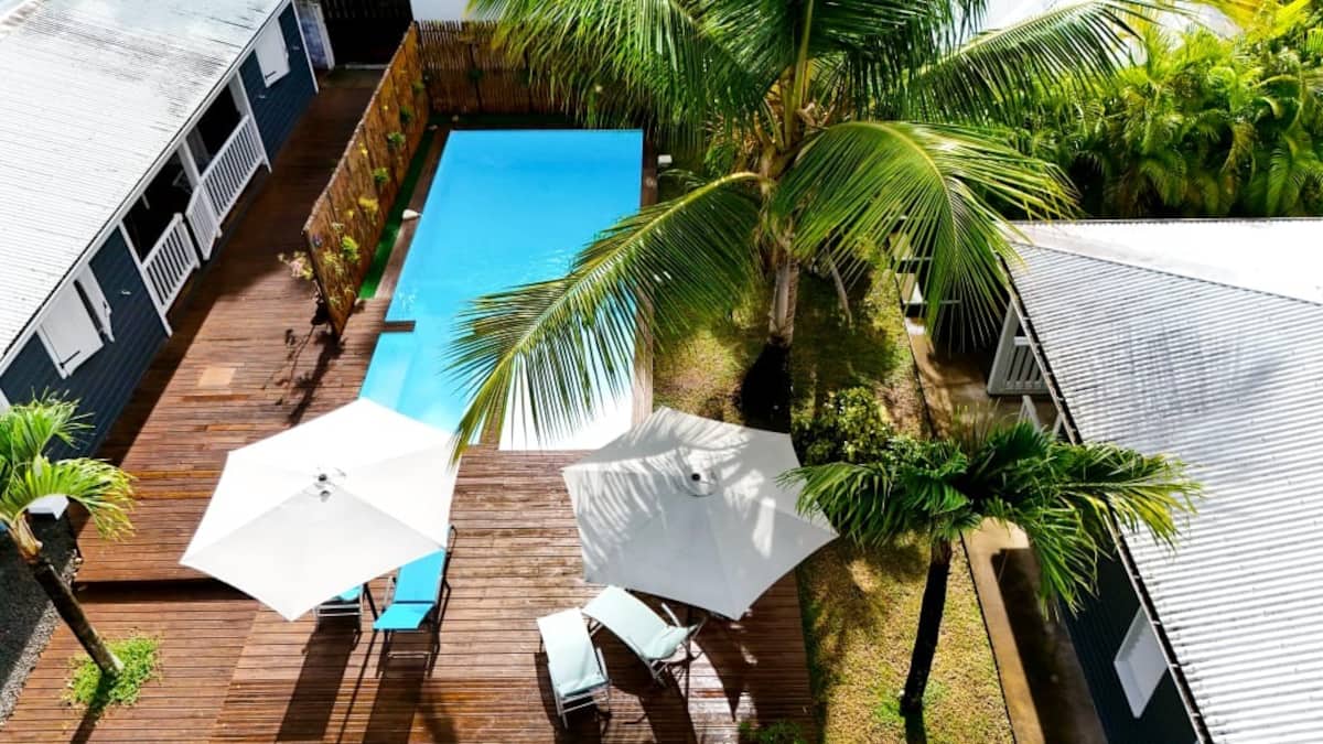 Piscine et bungalows au milieu des palmiers du Bungalow Lukila