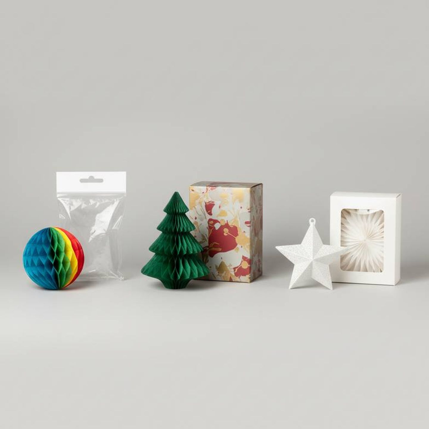 A collection of honeycomb paper decorations in different retail packaging options, including polybags, window boxes, and colorful printed boxes.