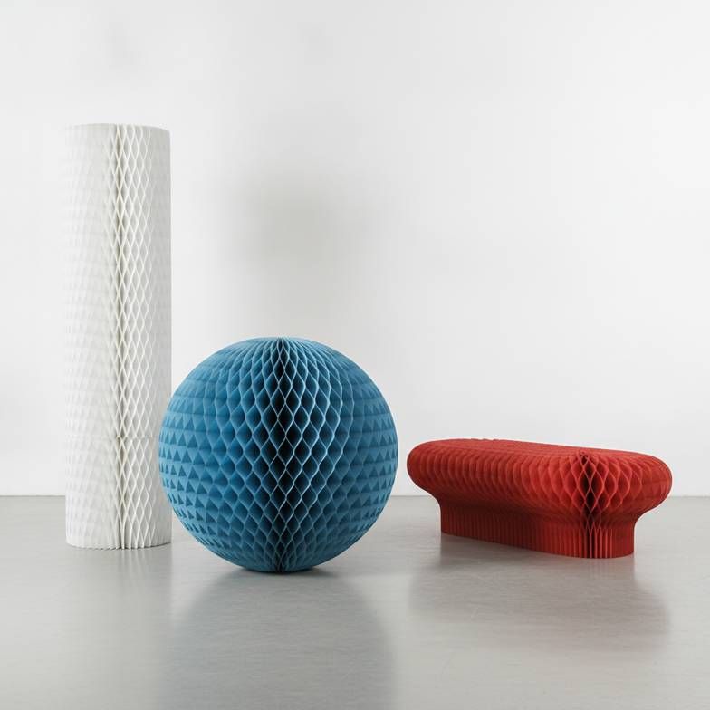 A collection of large honeycomb paper display props in various shapes and colors arranged in a retail setting.