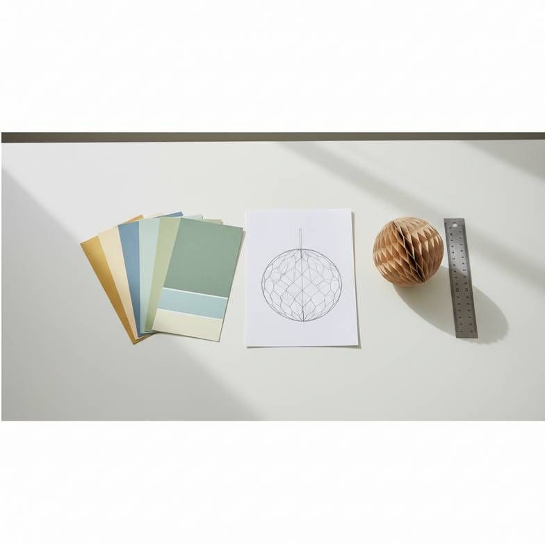A designer's desk showing paper swatches, a structural diagram, and a prototype of a honeycomb decoration.