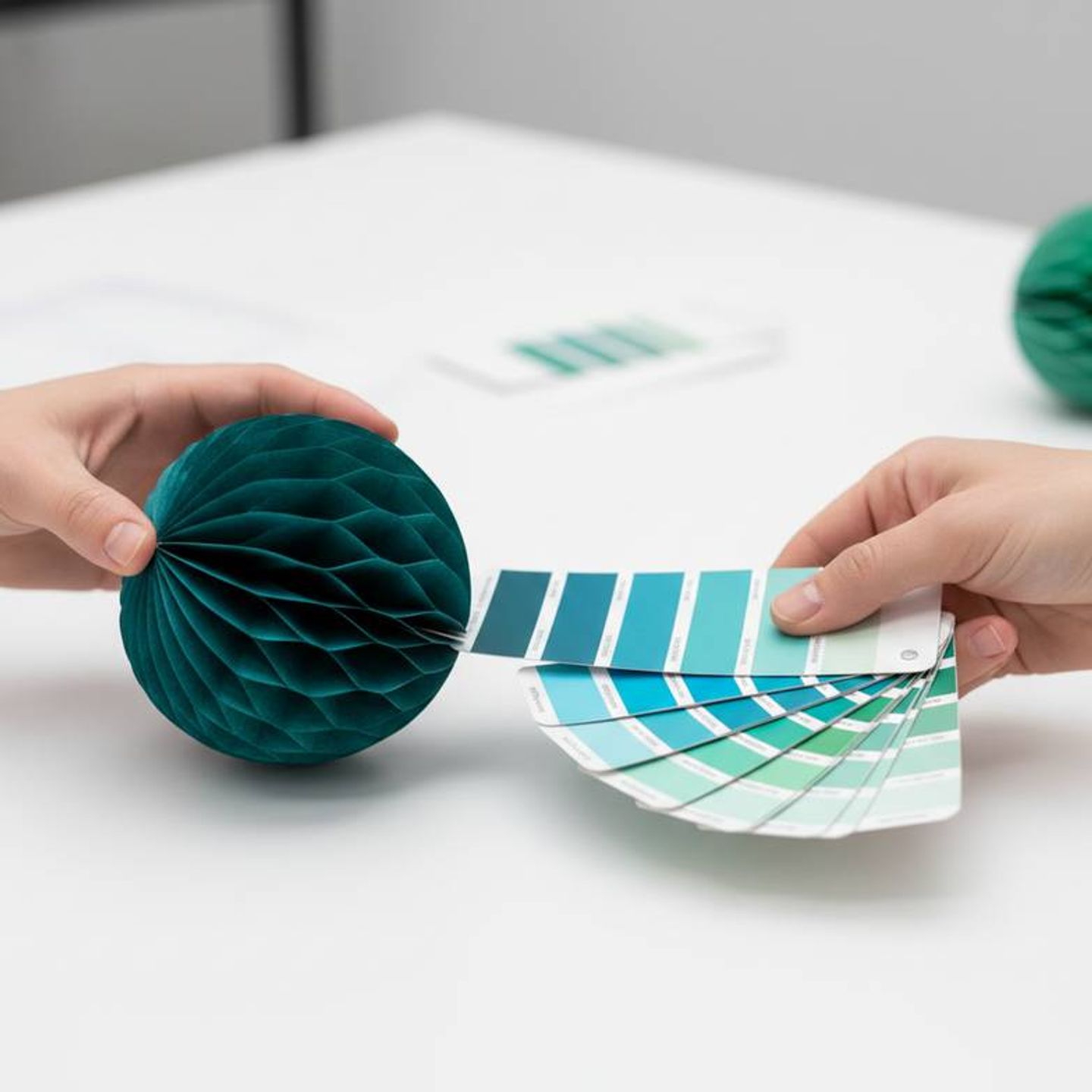 A designer reviewing Pantone swatches and a pre-production sample of a custom paper decoration