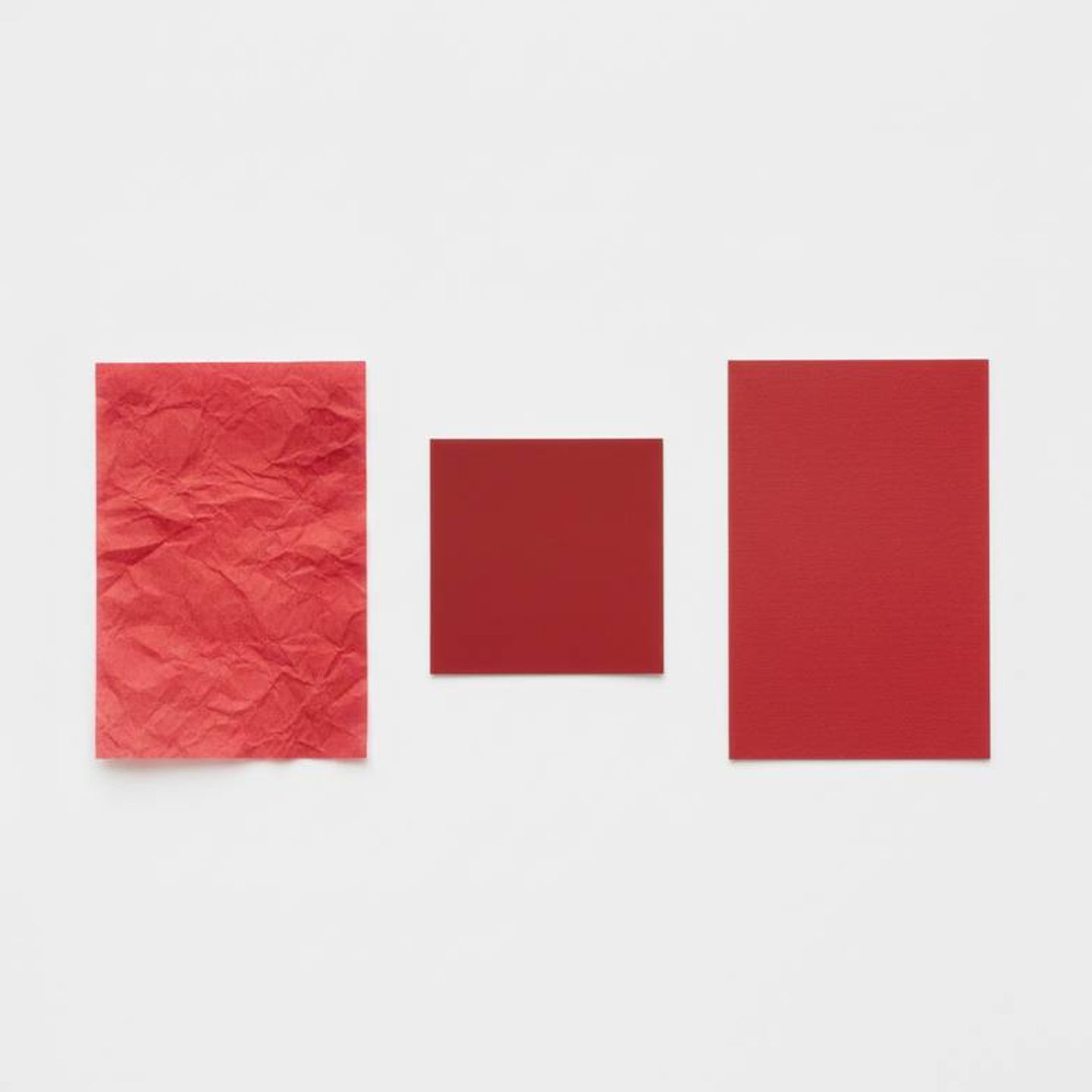 Comparing a Pantone color swatch to two different paper stocks to show color variation