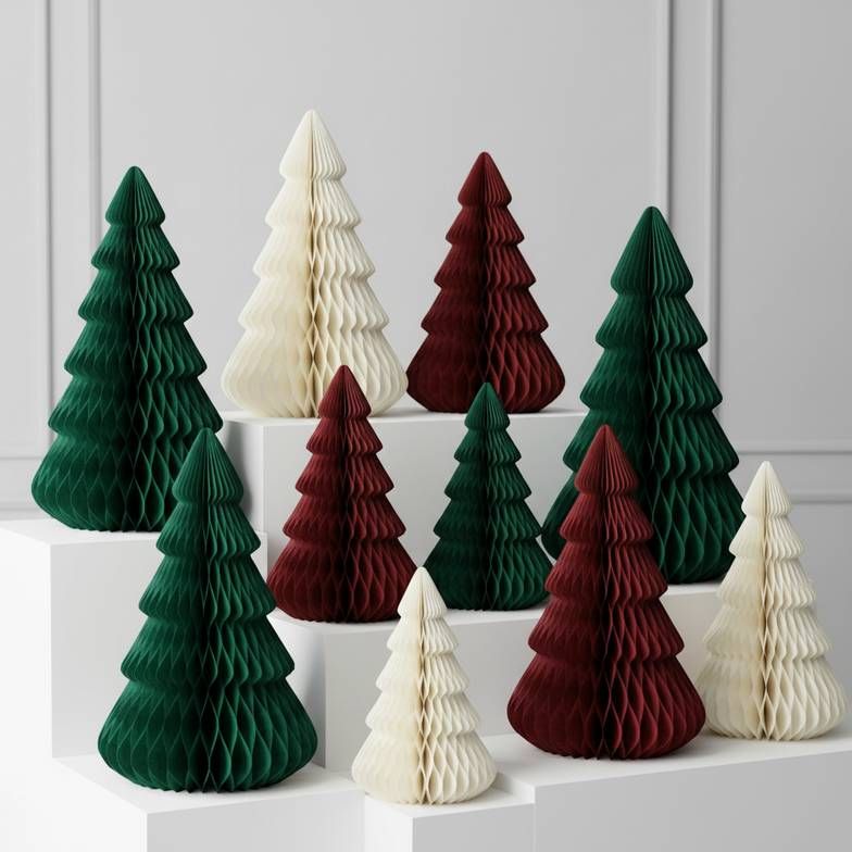 A collection of foldable paper Christmas trees in various sizes and colors arranged for a retail display.