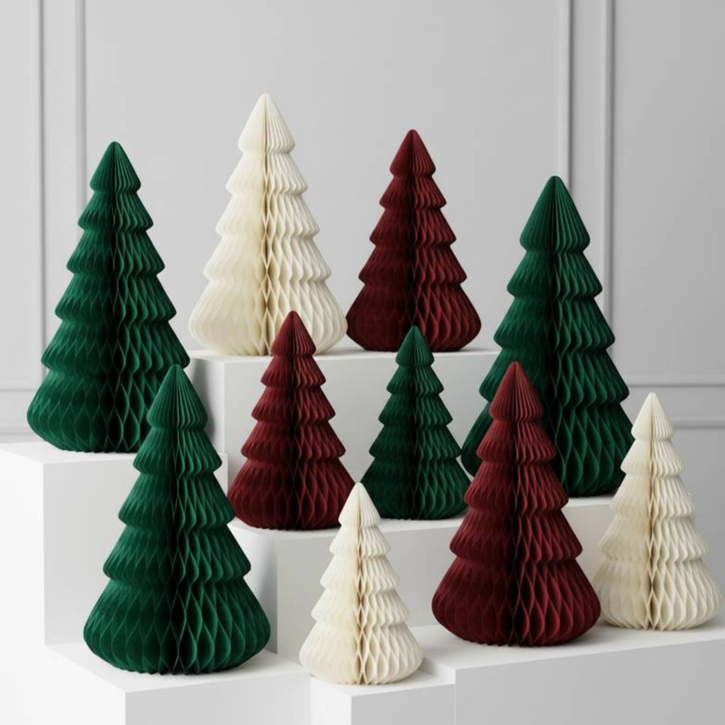 A collection of foldable paper Christmas trees in various sizes and colors arranged for a retail display.