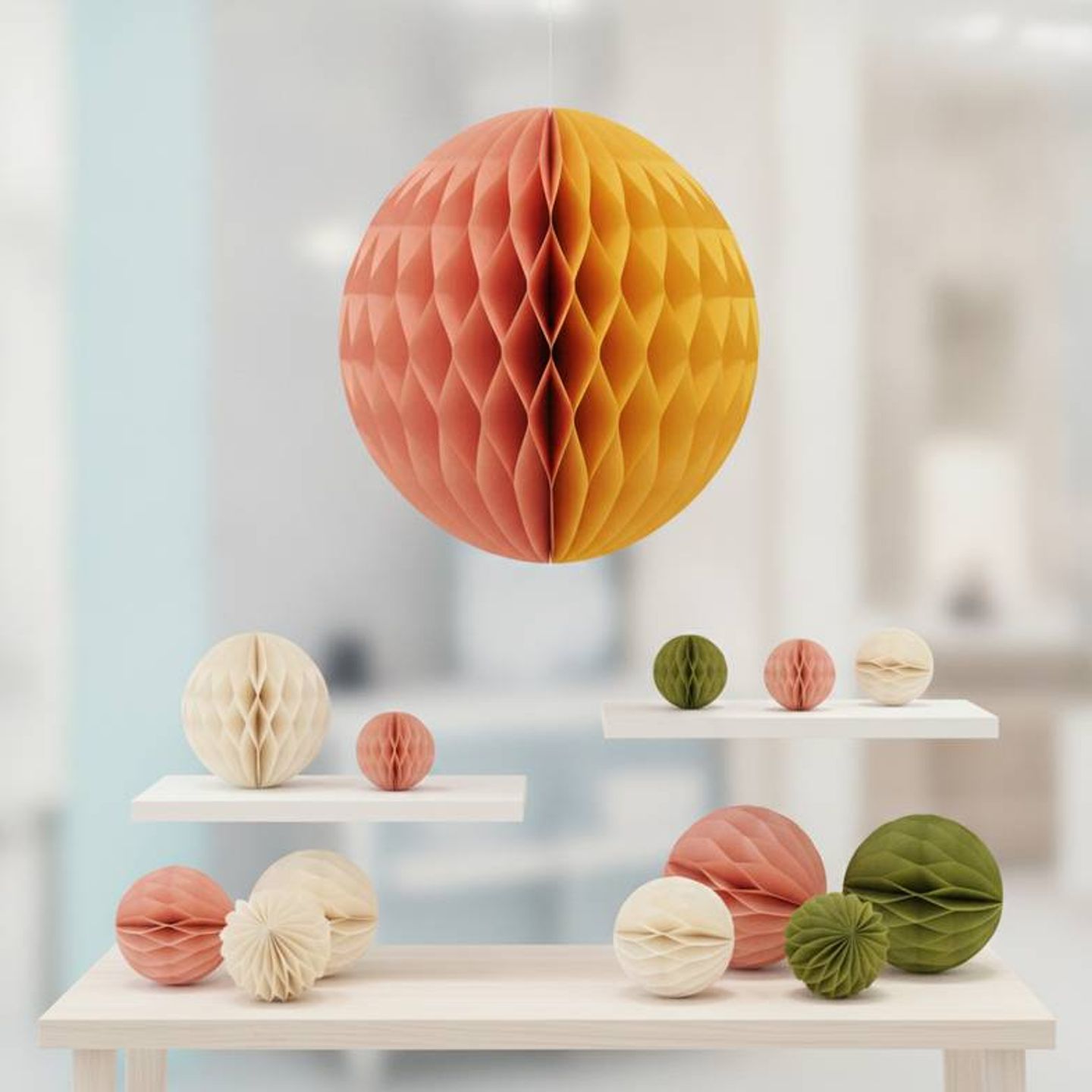 Large hero paper decoration in a store window with smaller filler honeycomb items on nearby shelves.
