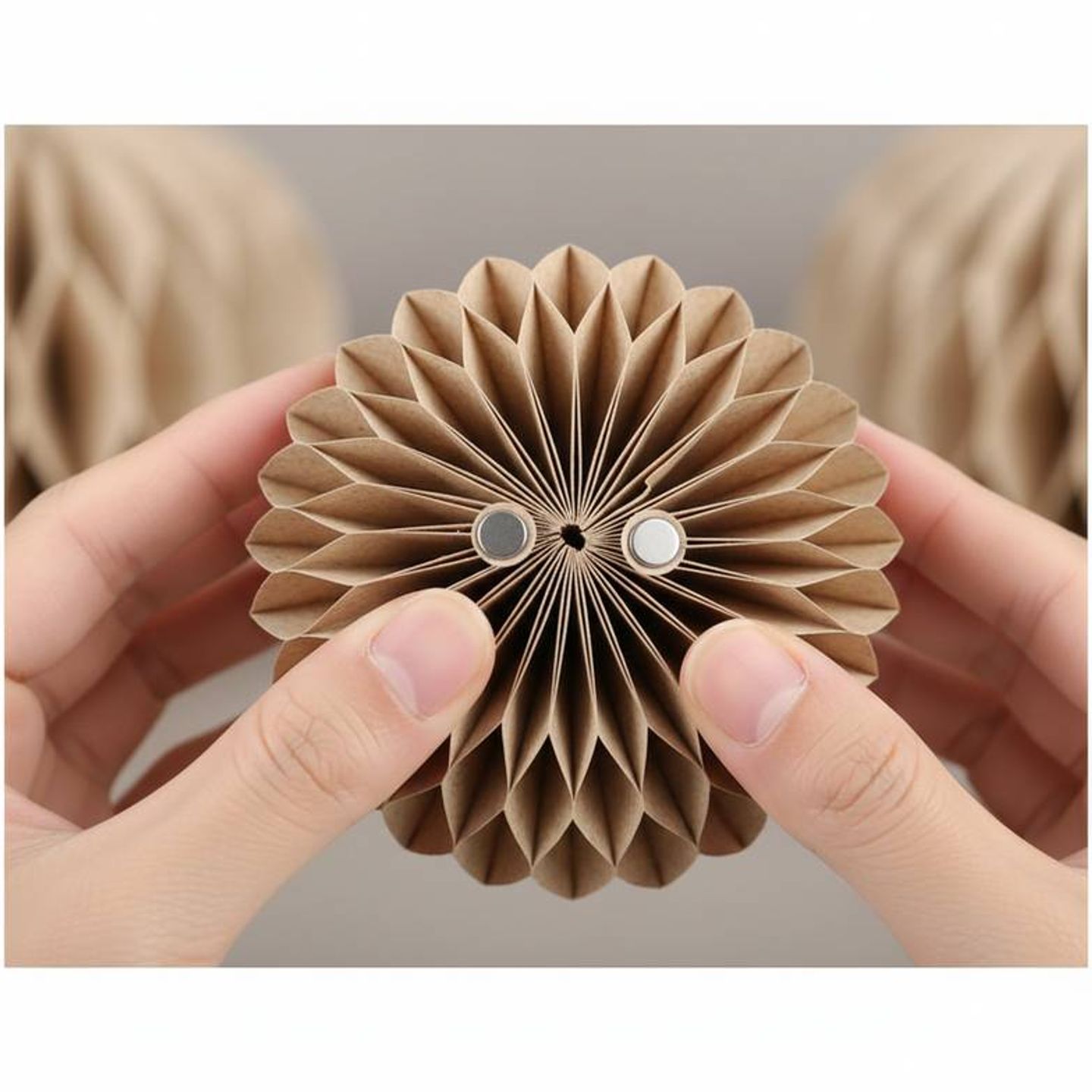 Close-up of a hand testing the magnetic closure of a honeycomb paper decoration sample