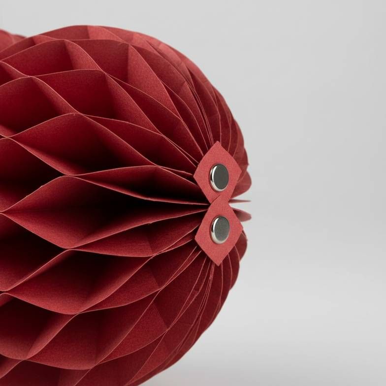 A close-up of a foldable honeycomb paper decoration showing the clean magnetic closures that allow for easy assembly and reuse.