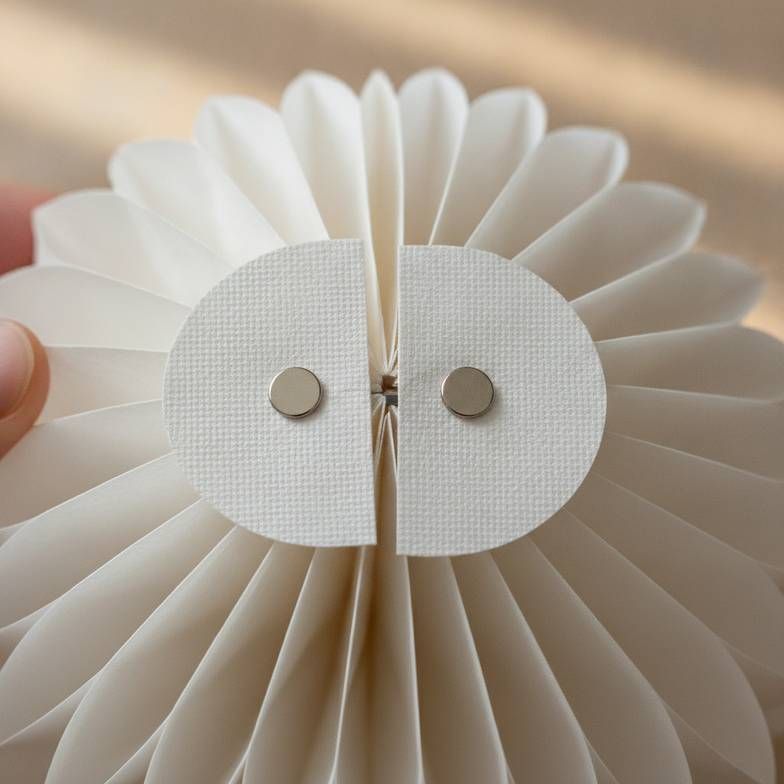A close-up of a honeycomb paper decoration's magnetic closure, showing its reusability and clean finish.