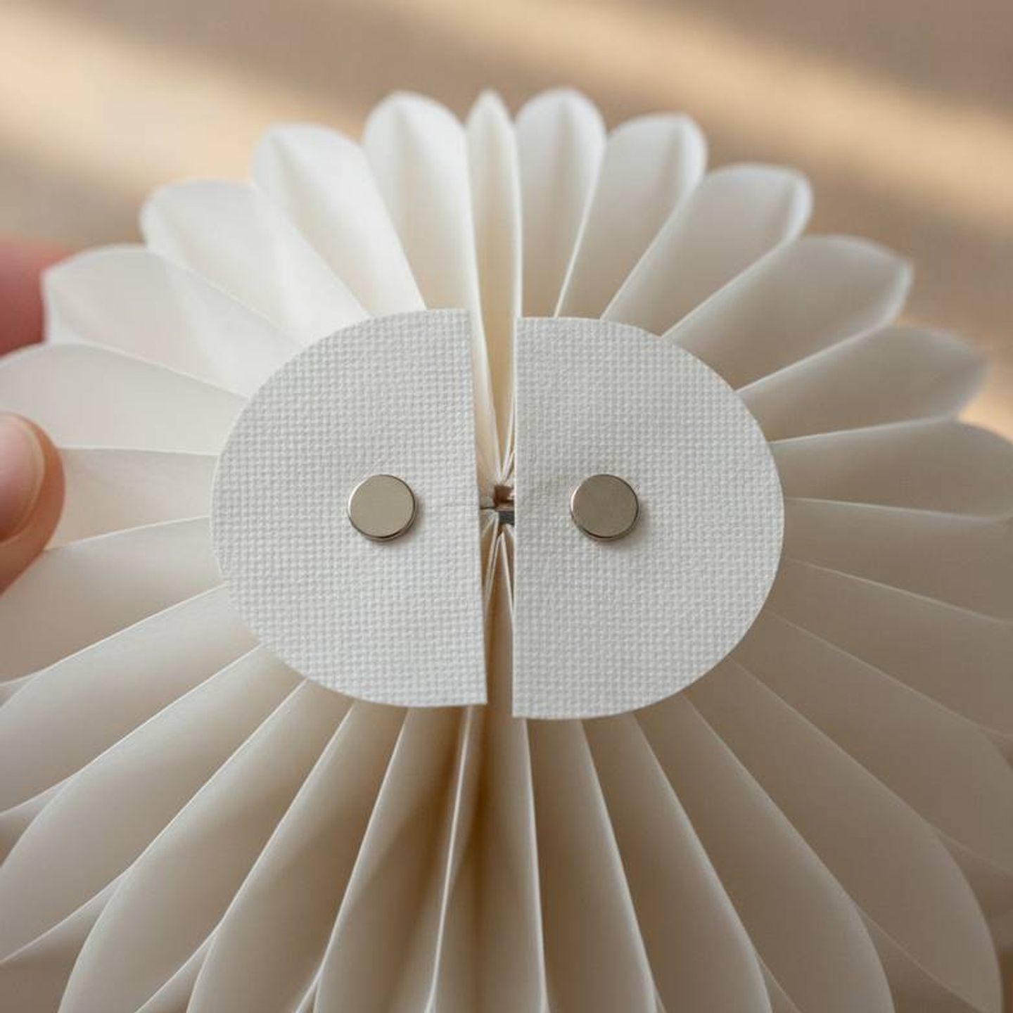 A close-up of a honeycomb paper decoration's magnetic closure, showing its reusability and clean finish.